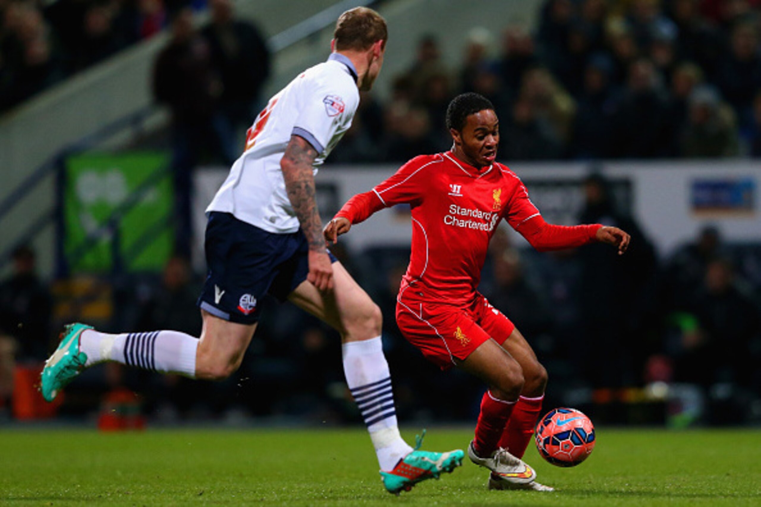 BOLTON, ENGLAND - FEBRUARY 04:  Raheem Sterling of Liverpool takes on David Wheater of Bolton Wanderers during the FA Cup Fourth round replay between Bolton Wanderers and Liverpool at Macron Stadium on February 4, 2015 in Bolton, England.  (Photo by Alex 