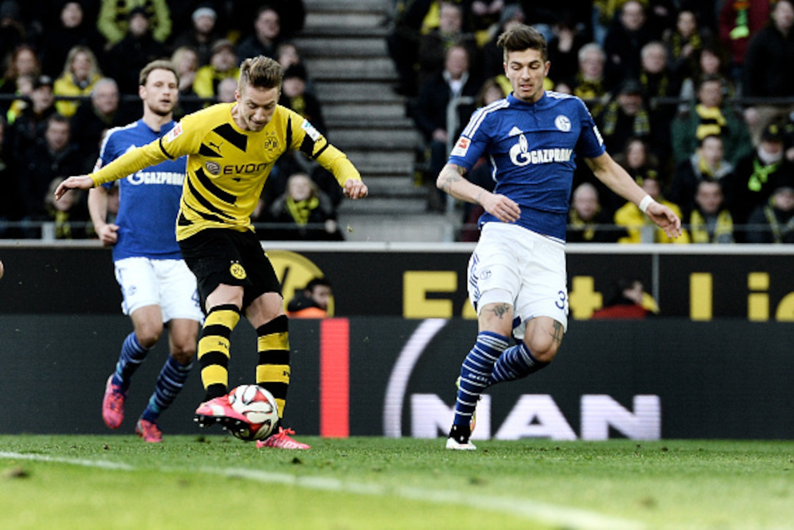 DORTMUND, GERMANY - FEBRUARY 28:  Marco Reus (L) of Dortmund fires a shot towards the Schalke goal during the Bundesliga match between Borussia Dortmund and FC Schalke 04 at Signal Iduna Park on February 28, 2015 in Dortmund, Germany.  (Photo by Sascha St
