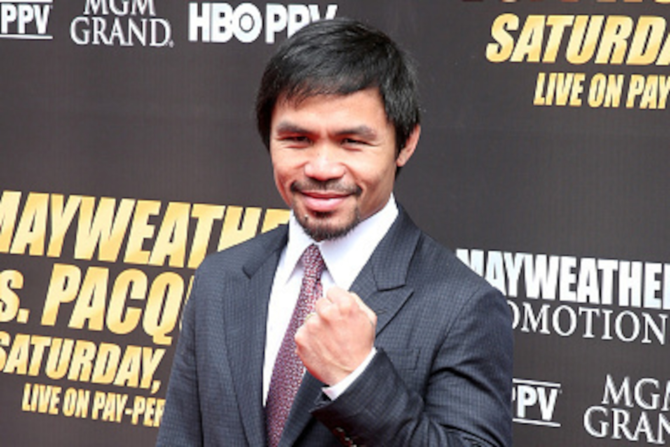 LOS ANGELES, CA - MARCH 11:  Manny Pacquiao poses for the media as he arrives for the Floyd Mayweather v Manny Pacquiao Press Conference promoting their ucoming fight on March 11, 2015 in Los Angeles, California.  (Photo by Stephen Dunn/Getty Images)