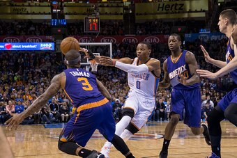 OKLAHOMA CITY, OK - DECEMBER 14: Russell Westbrook #0 of the Oklahoma City Thunder passes the ball against the Phoenix Suns at the Chesapeake Energy Arena  on December 14, 2013 in Oklahoma City, Oklahoma. NOTE TO USER:  User expressly acknowledges and agr