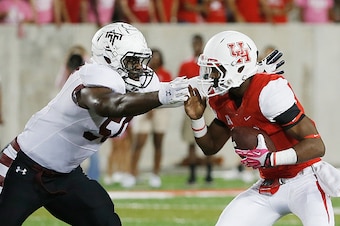 HOUSTON, TX - OCTOBER 17:  Greg Ward Jr. #1 of the Houston Cougars fights off a tackle by Praise Martin-Oguike #50 of the Temple Owls in the first half of their game at TDECU Stadium on October 17, 2014 in Houston, Texas.  (Photo by Scott Halleran/Getty I