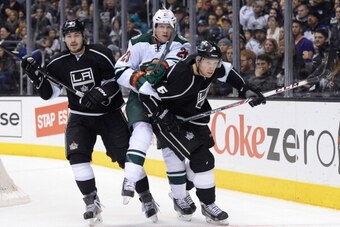 LOS ANGELES, CA - JANUARY 07:  Ryan Suter #20 of the Minnesota Wild is sandwiched between Drew Doughty #8 and Jake Muzzin #6 of the Los Angeles Kings during a 2-1 Wild win at Staples Center on January 7, 2014 in Los Angeles, California.  (Photo by Harry H
