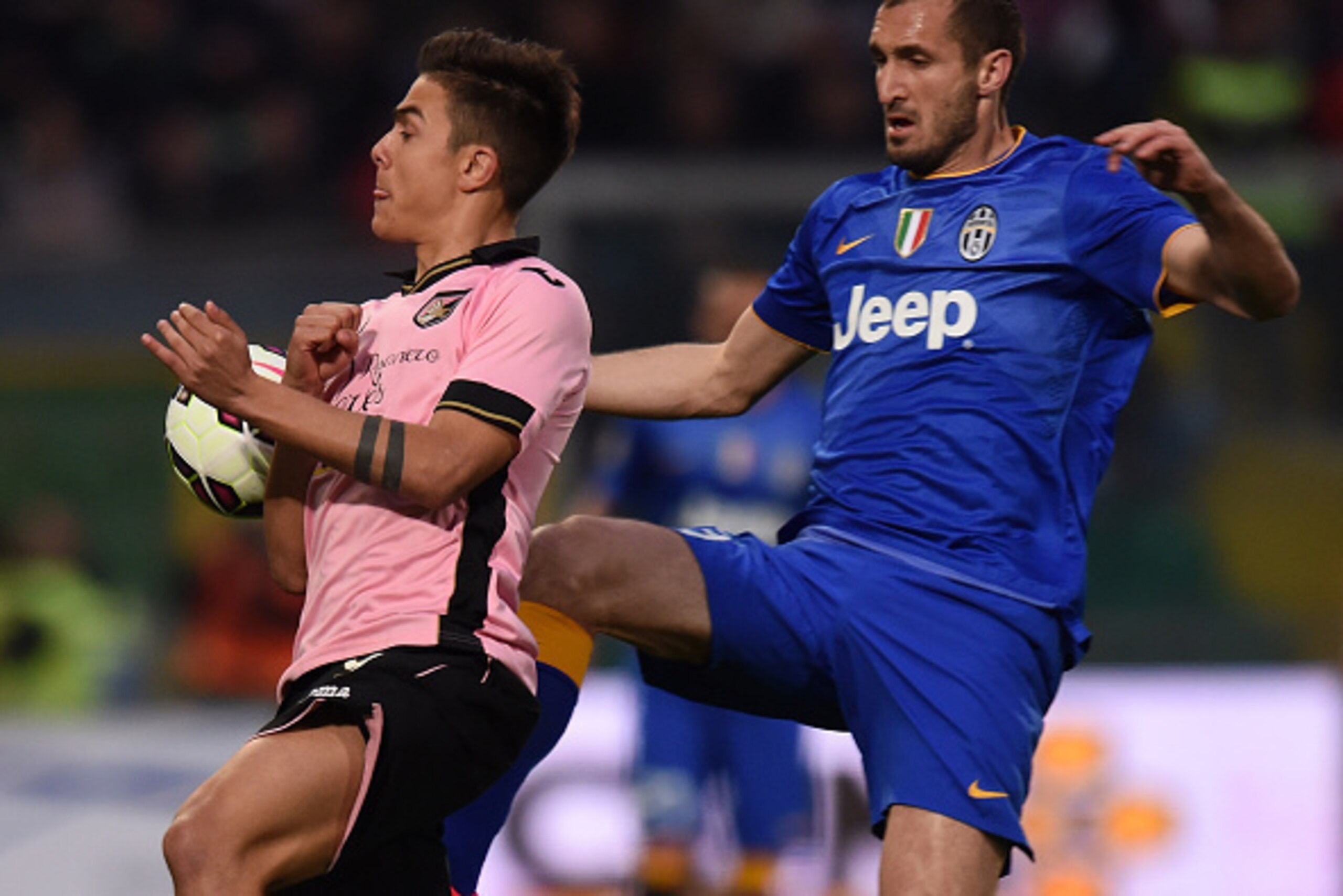 PALERMO, ITALY - MARCH 14:  Paulo Dybala (L) of Palermo and Giorgio Chiellini of Juventus compete for the ball during the Serie A match between US Citta di Palermo and Juventus FC  at Stadio Renzo Barbera on March 14, 2015 in Palermo, Italy.  (Photo by Tu