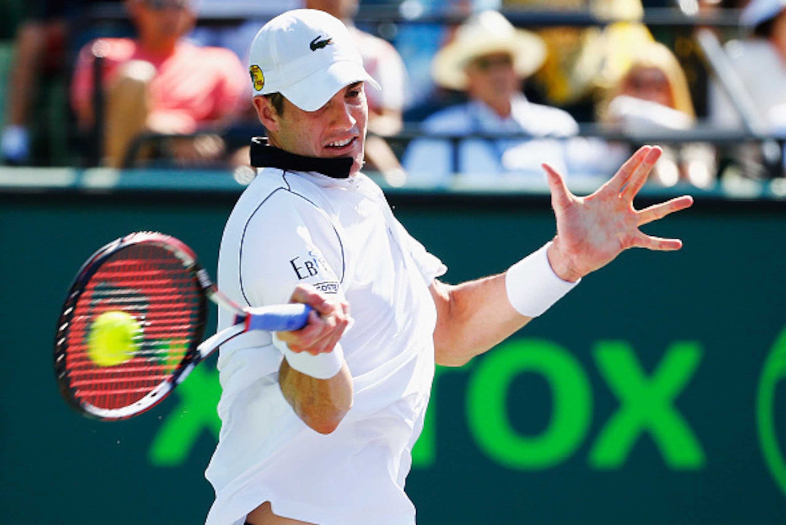 KEY BISCAYNE, FL - APRIL 02:  John Isner returns the ball against  Kei Nishikori of Japan during day 11 of the Miami Open at Crandon Park Tennis Center on April 2, 2015 in Key Biscayne, Florida.  (Photo by Al Bello/Getty Images)