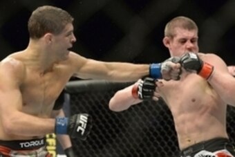 Jan 31, 2015; Las Vegas, NV, USA; Al Iaquinta (blue gloves) connects a punch on Joe Lauzon (red gloves) during their lightweight bout during UFC 183 at the MGM Grand Garden Arena. Mandatory Credit: Jayne Kamin-Oncea-USA TODAY Sports