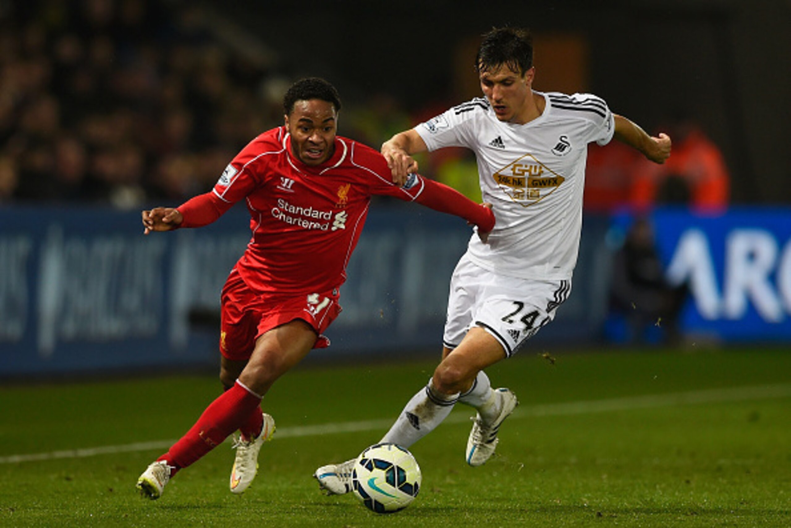 SWANSEA, WALES - MARCH 16:  Raheem Sterling of Liverpool is challenged by Jack Cork of Swansea during the Barclays Premier League match between Swansea City and Liverpool at Liberty Stadium on March 16, 2015 in Swansea, Wales.  (Photo by Mike Hewitt/Getty