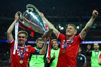 LONDON, ENGLAND - MAY 25:  Philipp Lahm of Bayern Muenchen (L) holds the trophy as he celebrates with team-mate Bastian Schweinsteiger after winning the UEFA Champions League final match against Borussia Dortmund at Wembley Stadium on May 25, 2013 in Lond