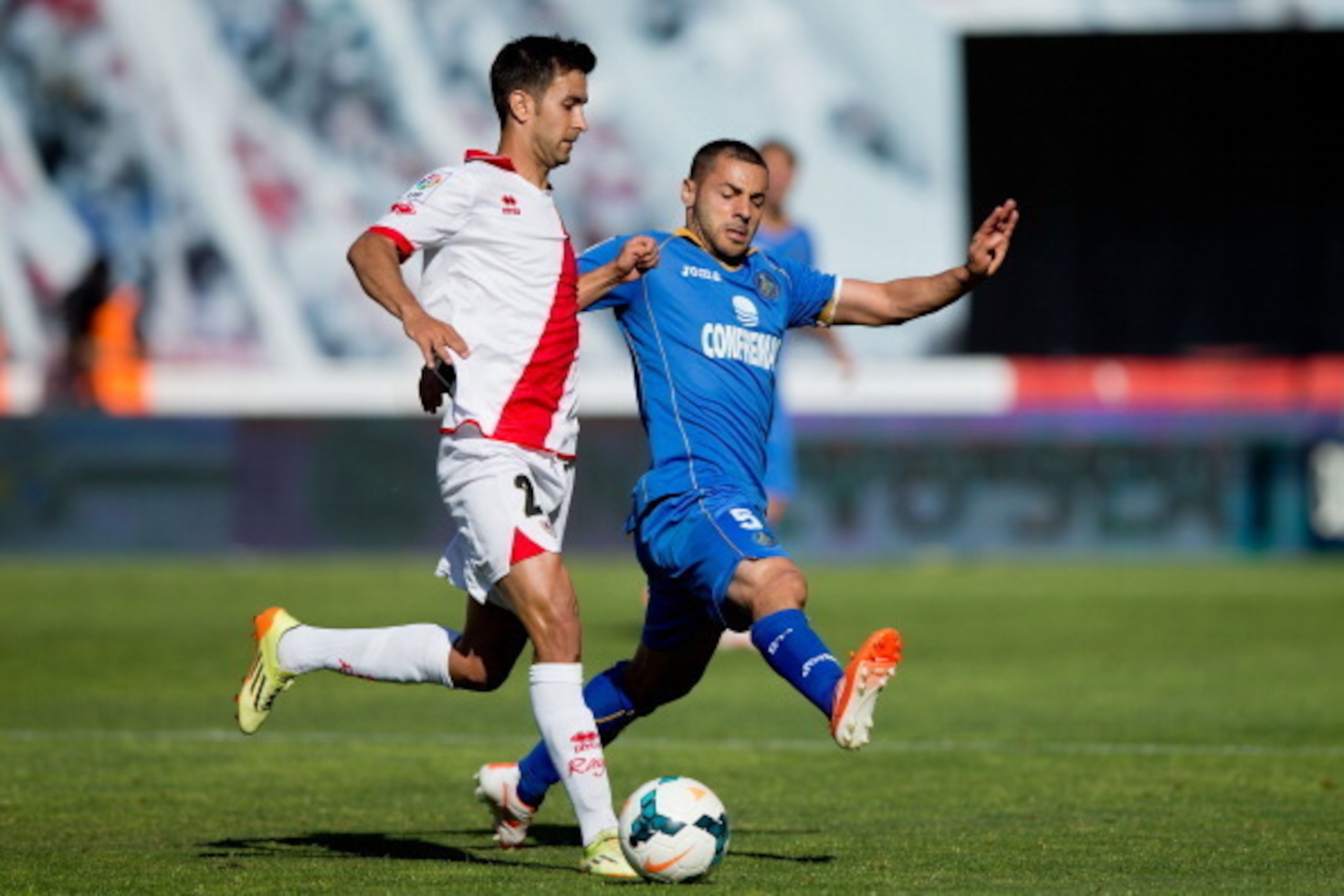 MADRID, SPAIN - MAY 18: Alberto Bueno (L) of Rayo Vallecano de Madrid competes for the ball with Mehdi Gregory Guiseppe Lacen (R) of Getafe CF during the La Liga match between Rayo Vallecano de Madrid and Getafe CF at Estadio de Vallecas on May 18, 2014 i