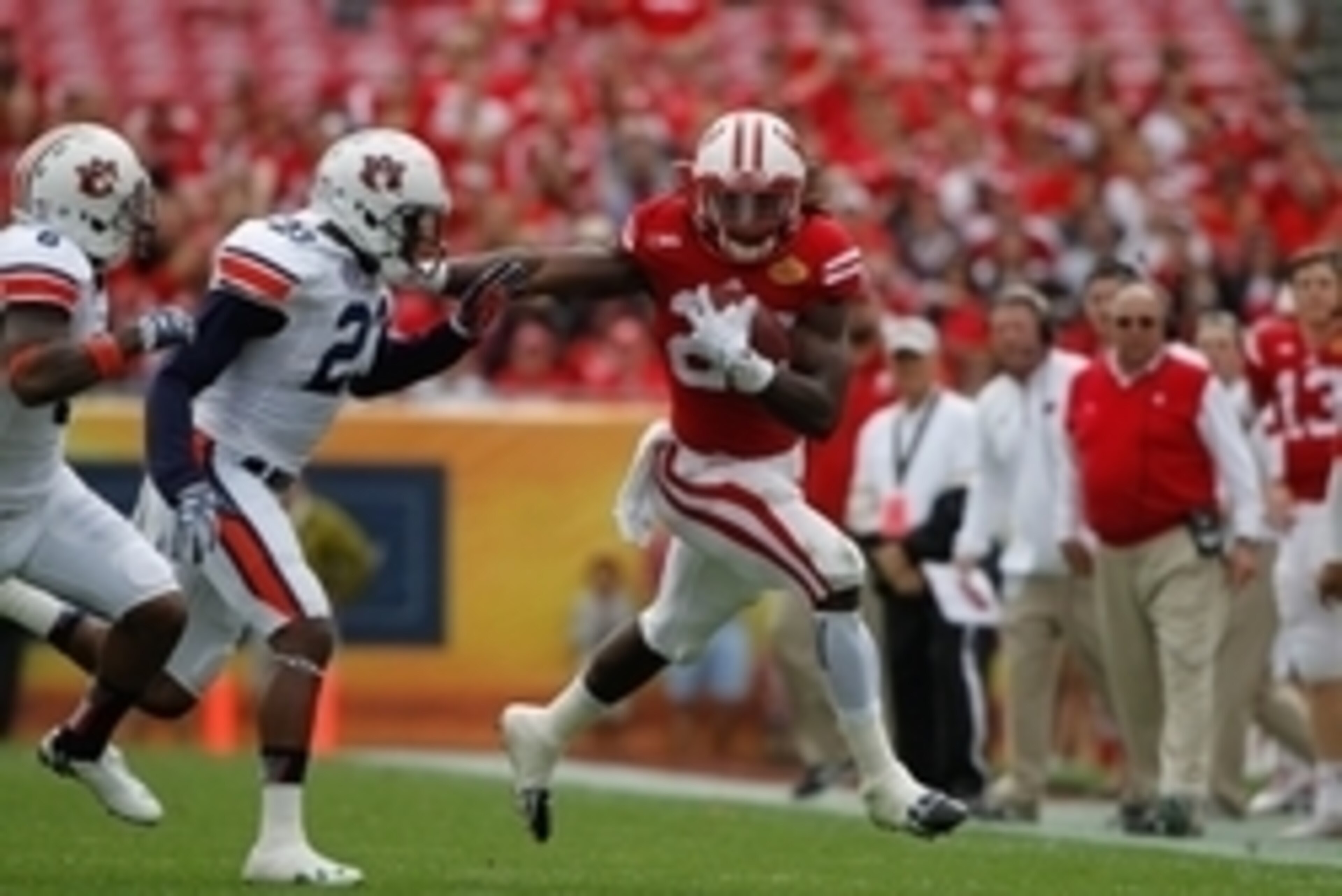 Jan 1, 2015; Tampa, FL, USA; Wisconsin Badgers running back Melvin Gordon (25) stiff arms Auburn Tigers defensive back Johnathan Ford (23) during the first half in the 2015 Outback Bowl at Raymond James Stadium. Mandatory Credit: Kim Klement-USA TODAY Spo