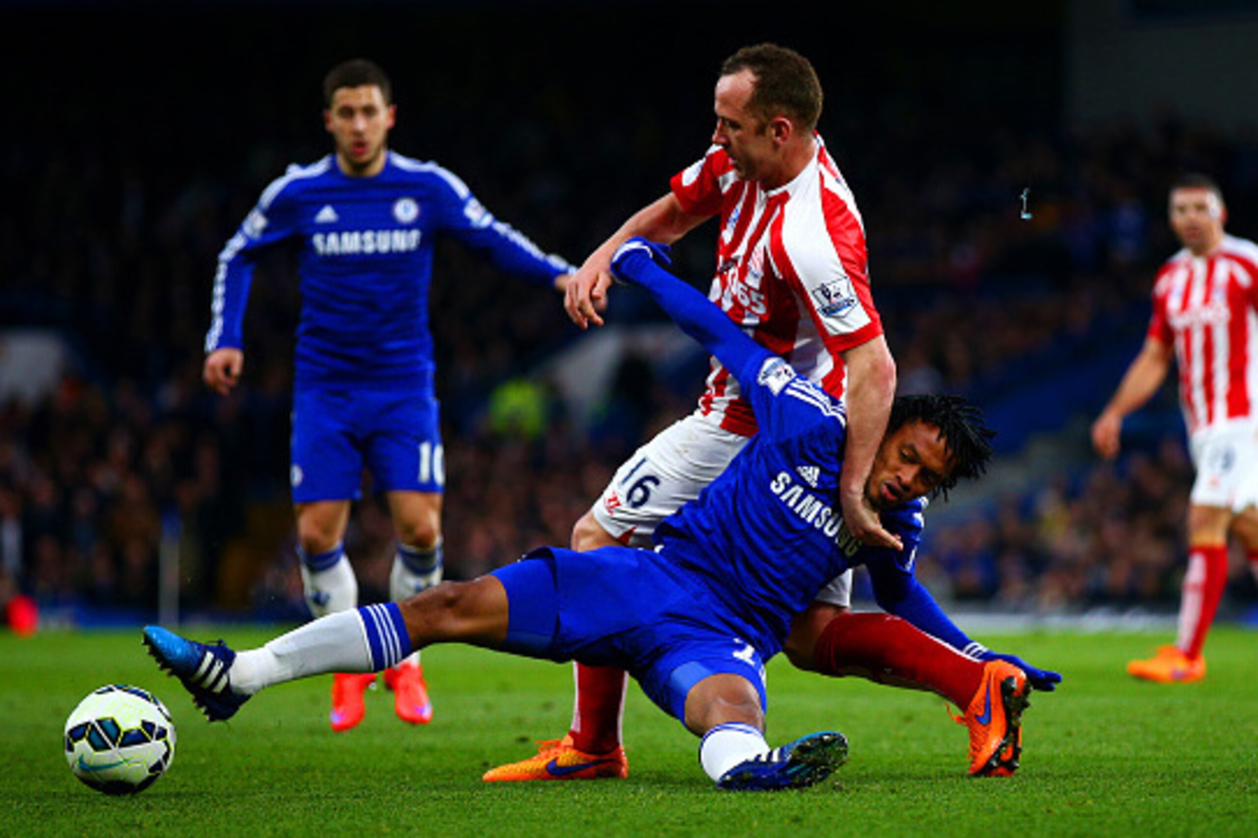LONDON, ENGLAND - APRIL 04:  Juan Cuadrado of Chelsea battles for the ball with Charlie Adam of Stoke City during the Barclays Premier League match between Chelsea and Stoke City at Stamford Bridge on April 4, 2015 in London, England.  (Photo by Ian Walto