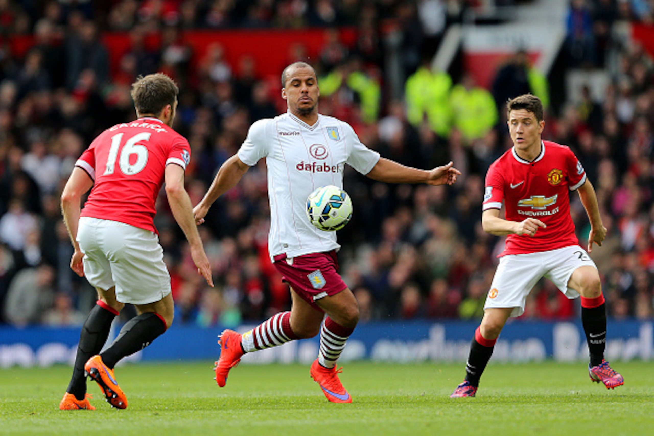 MANCHESTER, ENGLAND - APRIL 04:  Gabriel Agbonlahor of Aston Villa battles for the ball with Michael Carrick of Manchester United and Ander Herrera of Manchester United during the Barclays Premier League match between Manchester United and Aston Villa at 