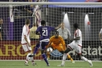 Apr 3, 2015; Orlando, FL, USA; Orlando City SC forward Cyle Larin (21) kicks as D.C. United goalkeeper Bill Hamid (28) defends during the second half at Orlando Citrus Bowl Stadium. D.C. United defeated the Orlando City SC 1-0. Mandatory Credit: Kim Kleme