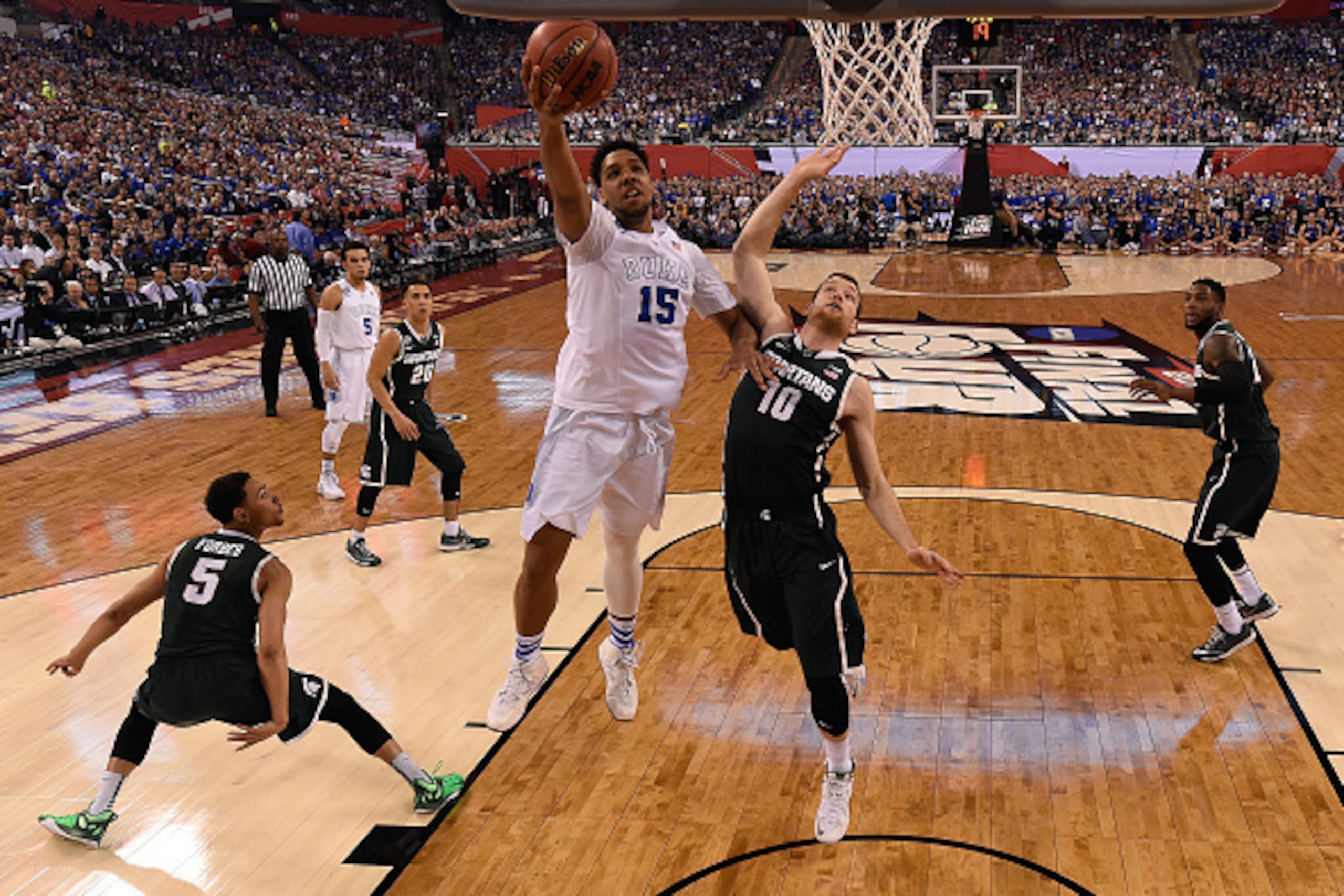 INDIANAPOLIS, IN - APRIL 04: Jahlil Okafor #15 of the Duke Blue Devils drives to the basket against Matt Costello #10 of the Michigan State Spartans in the first half during the NCAA Men's Final Four Semifinal at Lucas Oil Stadium on April 4, 2015 in Indi