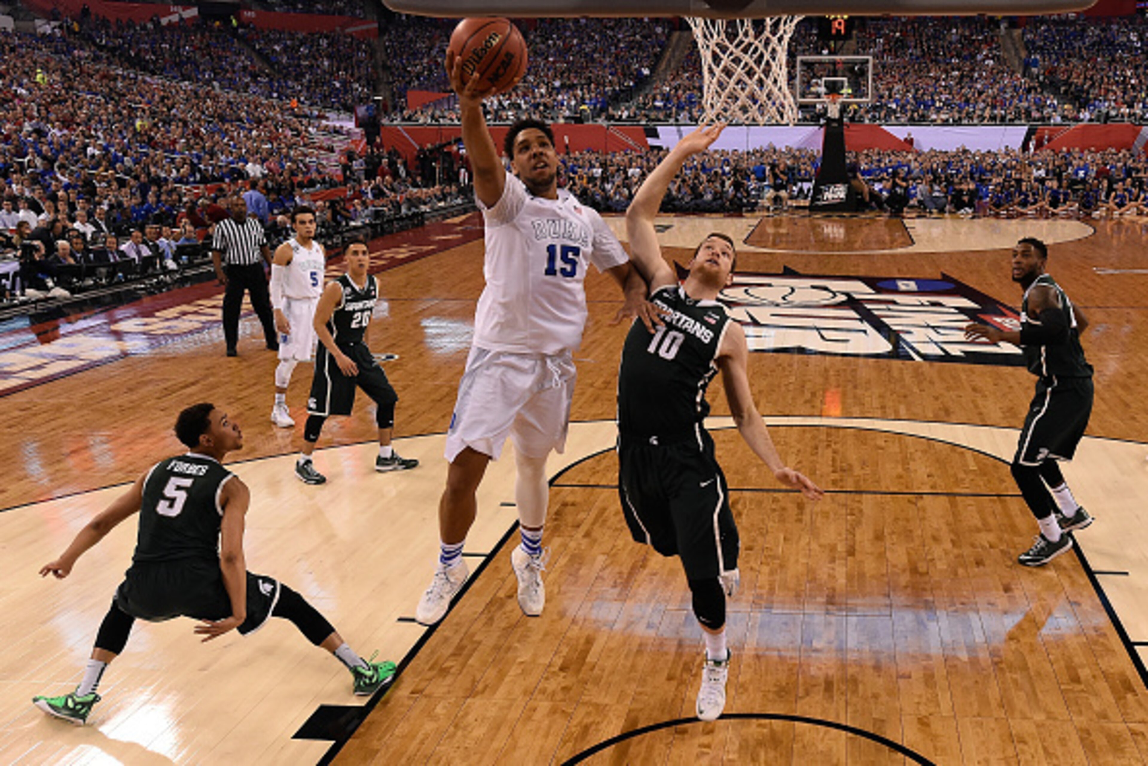 INDIANAPOLIS, IN - APRIL 04: Jahlil Okafor #15 of the Duke Blue Devils drives to the basket against Matt Costello #10 of the Michigan State Spartans in the first half during the NCAA Men's Final Four Semifinal at Lucas Oil Stadium on April 4, 2015 in Indi