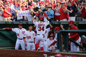 WASHINGTON, DC - APRIL 06: Bryce Harper #34 of the Washington Nationals celebrates in the dugout after hitting a solo home run against the New York Mets in the fourth inning during Opening Day at Nationals Park on April 6, 2015 in Washington, DC.  (Photo 