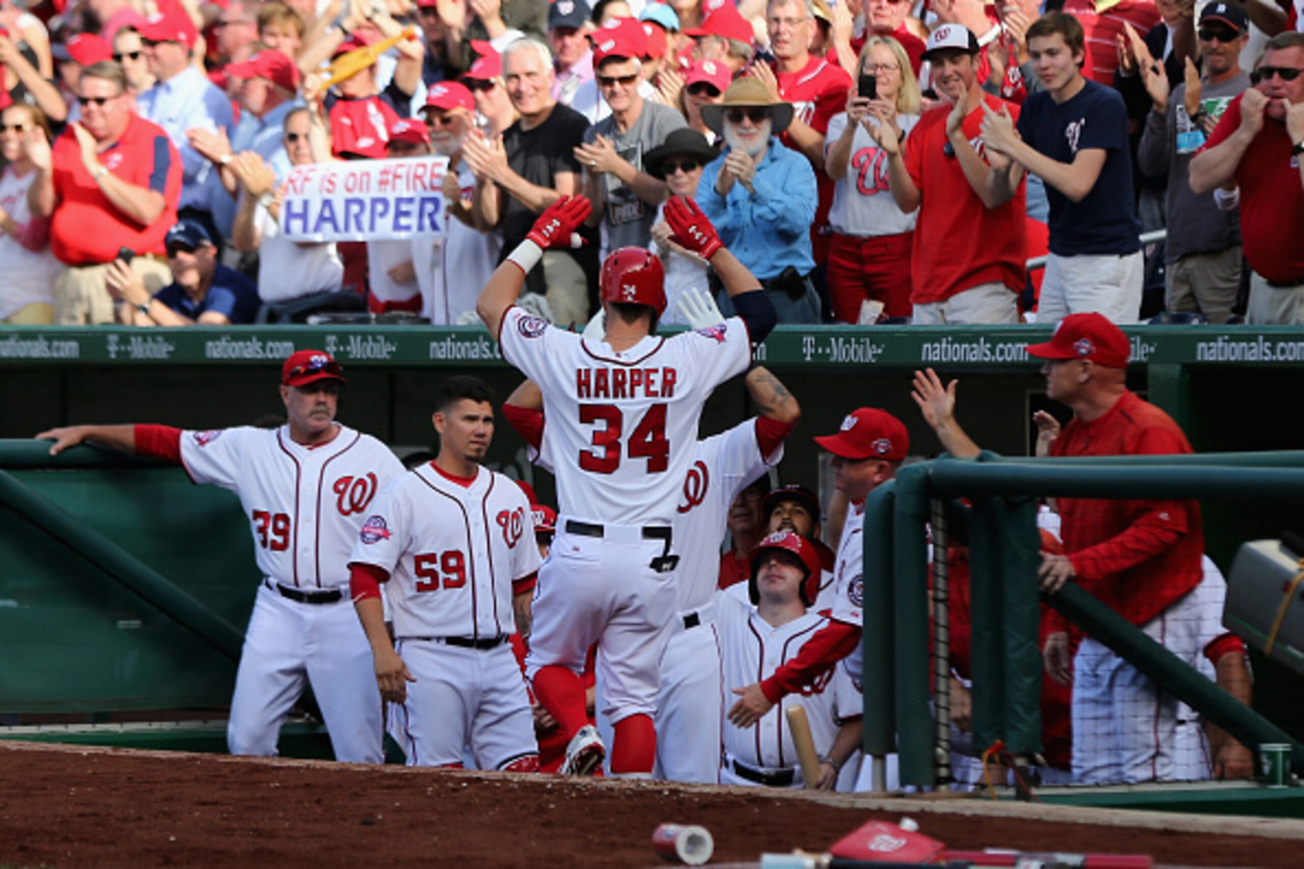 WASHINGTON, DC - APRIL 06: Bryce Harper #34 of the Washington Nationals celebrates in the dugout after hitting a solo home run against the New York Mets in the fourth inning during Opening Day at Nationals Park on April 6, 2015 in Washington, DC.  (Photo 