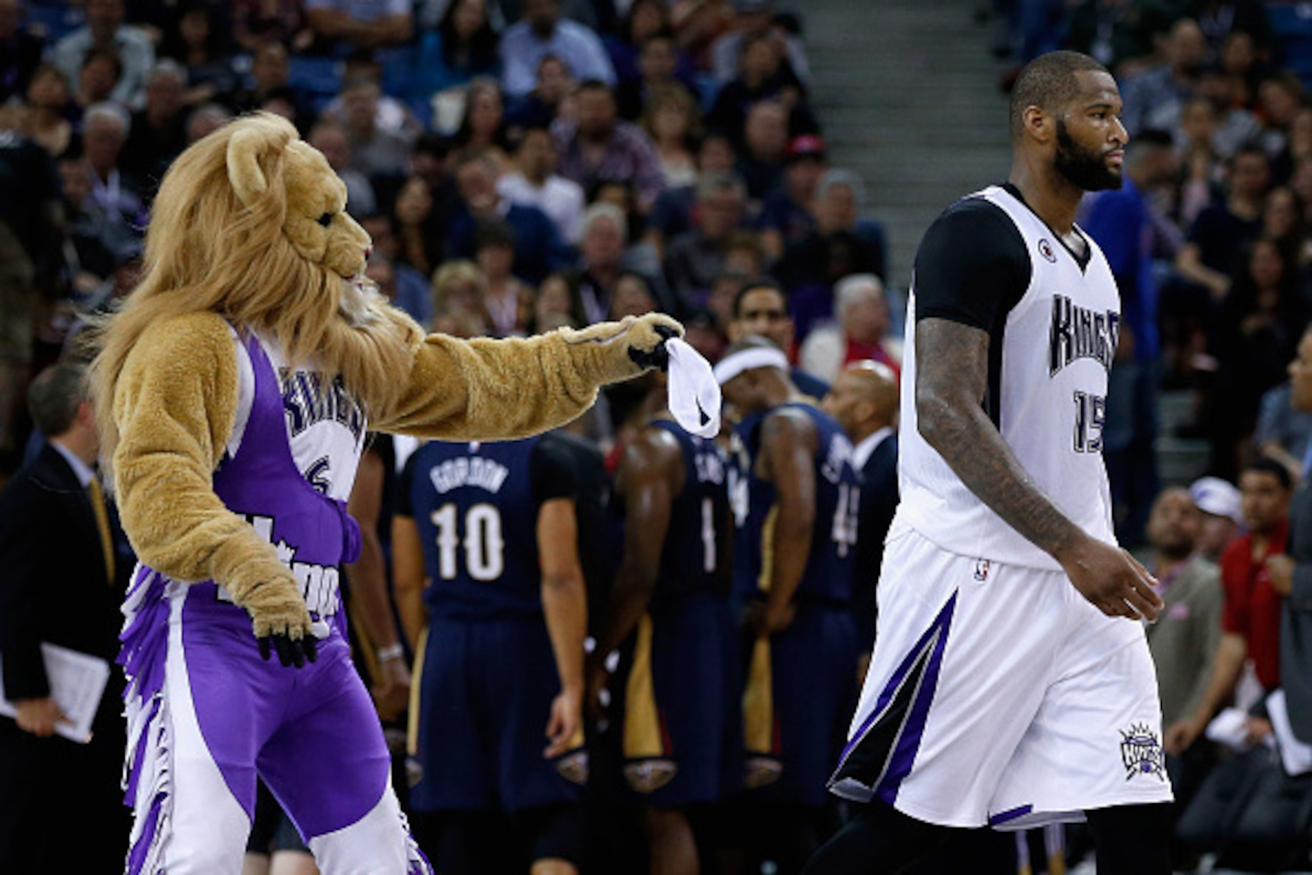 SACRAMENTO, CA - APRIL 03:  Slamson the Lion, the Sacramento Kings mascot, tries to give DeMarcus Cousins #15 back his head band after it fell off during their game against the New Orleans Pelicans at Sleep Train Arena on April 3, 2015 in Sacramento, Cali