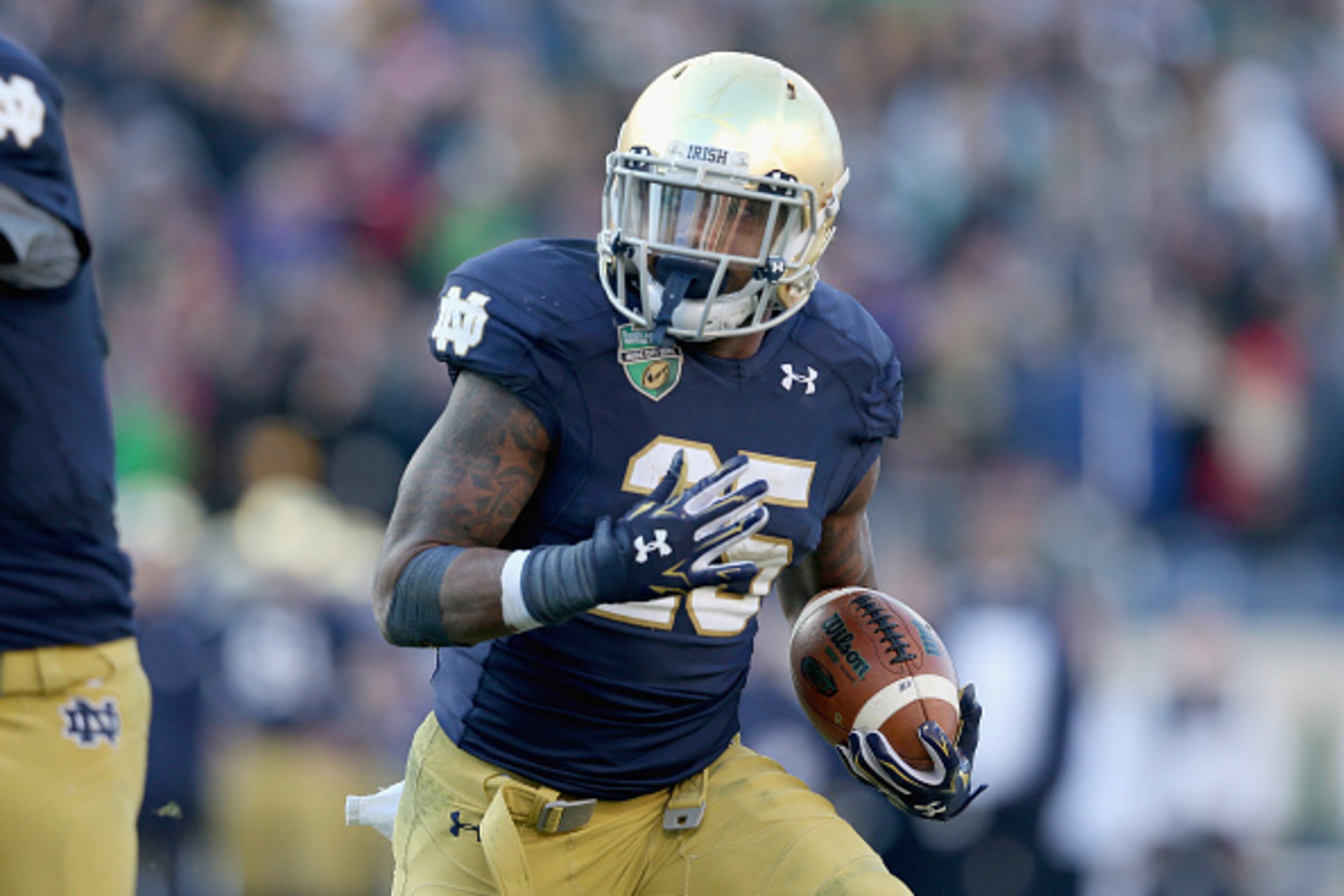 NASHVILLE, TN - DECEMBER 30:  Tarean Folston #25 of the Notre Dame Fighting Irish runs for a touchdown against the LSU Tigers during the Franklin American Mortgage Music City Bowl at LP Field on December 30, 2014 in Nashville, Tennessee.  (Photo by Andy L