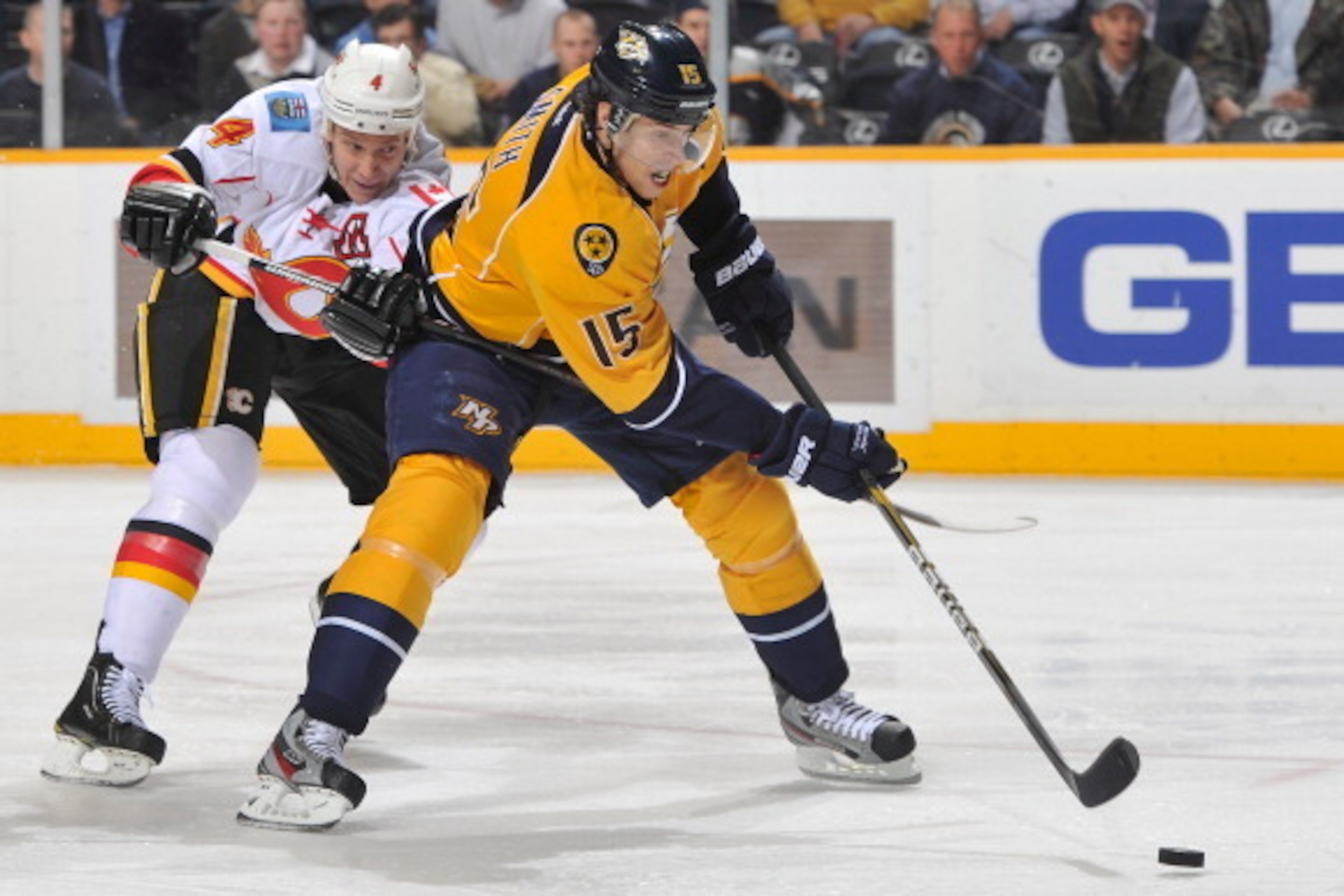 NASHVILLE, TN - DECEMBER 13: Jay Bouwmeester #4 of the Calgary Flames is called for hooking against Craig Smith #15 of the Nashville Predators during an NHL game at the Bridgestone Arena on December 13, 2011 in Nashville, Tennessee. (Photo by John Russell