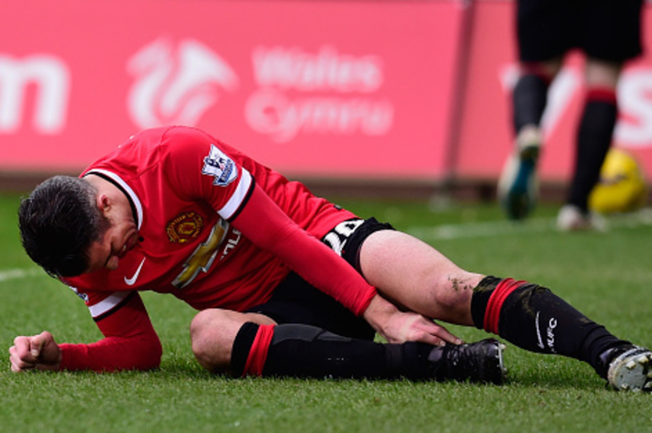 SWANSEA, WALES - FEBRUARY 21:  Robin Van Persie  of Manchester United lies injured during the Barclays Premier League match between Swansea City and Manchester United at Liberty Stadium on February 21, 2015 in Swansea, Wales.  (Photo by Stu Forster/Getty 