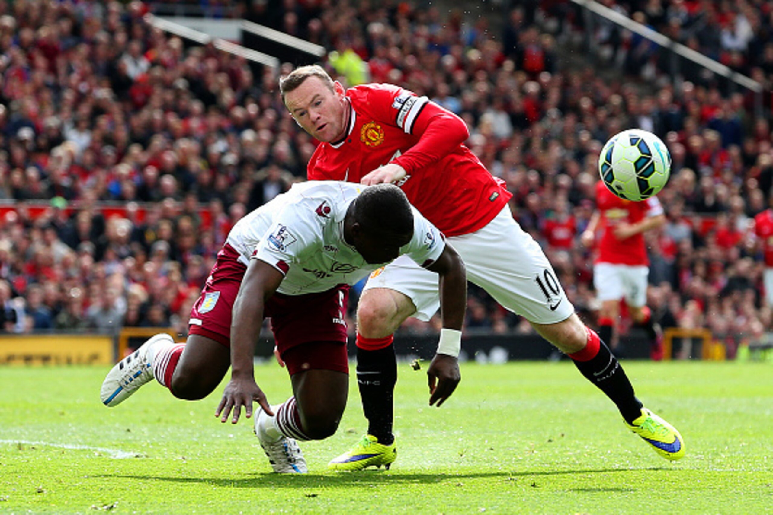 MANCHESTER, ENGLAND - APRIL 04:  Wayne Rooney of Manchester United battles for the ball with Jores Okore of Aston Villa during the Barclays Premier League match between Manchester United and Aston Villa at Old Trafford on April 4, 2015 in Manchester, Engl