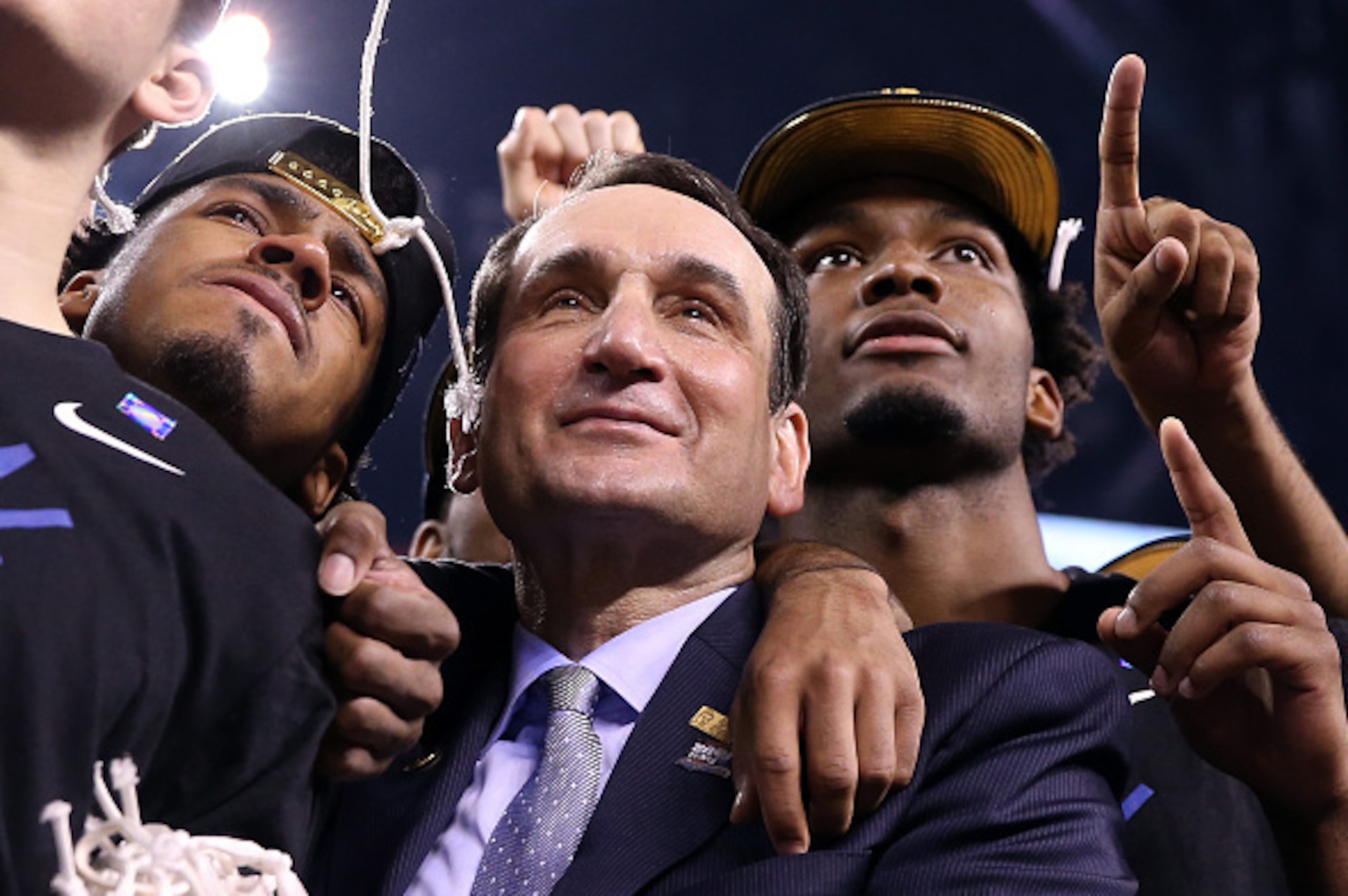 INDIANAPOLIS, IN - APRIL 06:  Head coach Mike Krzyzewski of the Duke Blue Devils watches 'One Shining Moment' with Quinn Cook #2 and Justise Winslow #12 after defeating the Wisconsin Badgers during the NCAA Men's Final Four National Championship at Lucas 