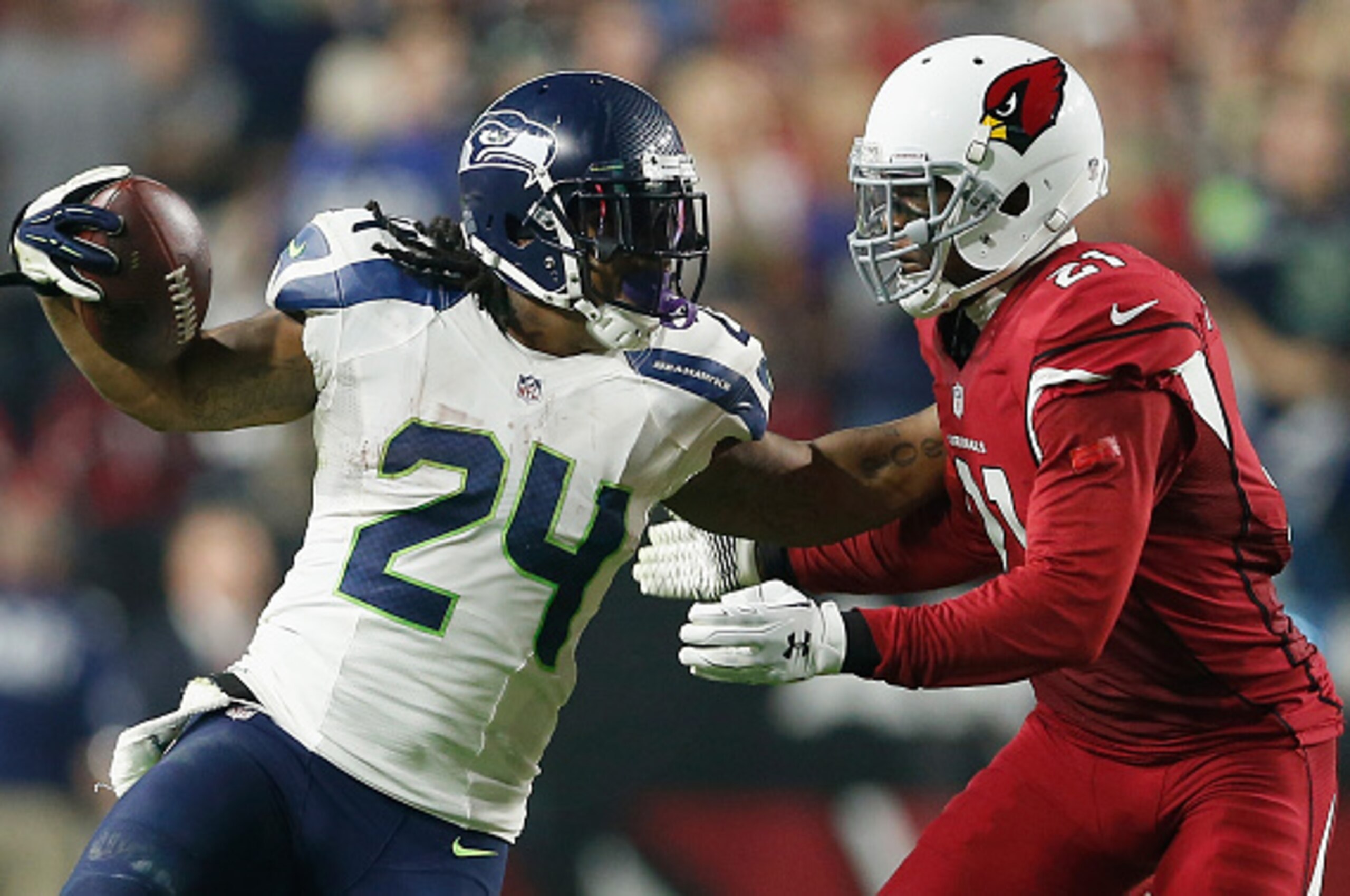 GLENDALE, AZ - DECEMBER 21:  Running back Marshawn Lynch #24 of the Seattle Seahawks pushes off cornerback Patrick Peterson #21 of the Arizona Cardinals to run in a 79 yard touchdown in the fourth quarter during the NFL game at the University of Phoenix S