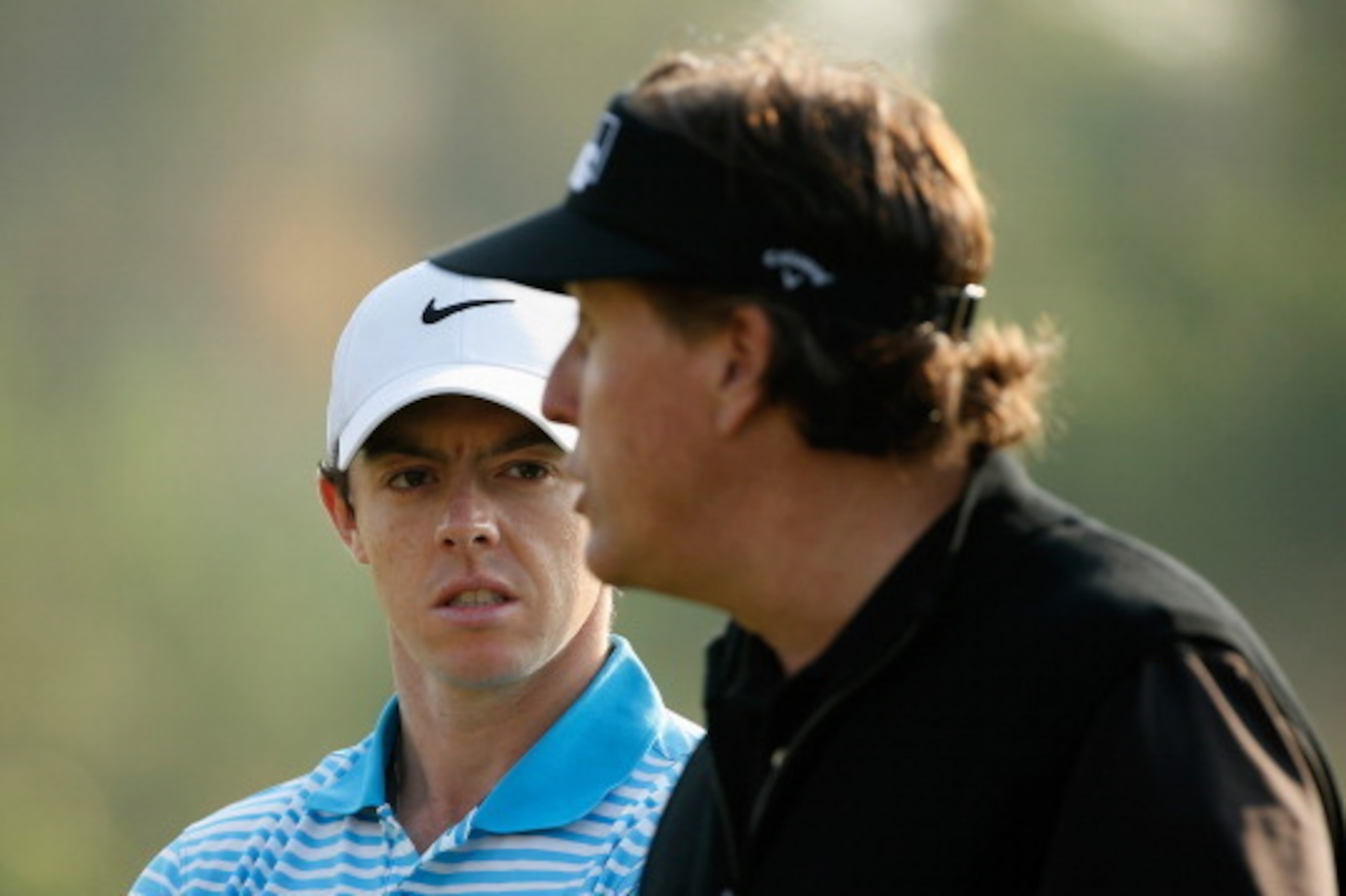 ABU DHABI, UNITED ARAB EMIRATES - JANUARY 16:  Rory McIlroy of Northern Ireland (L) waits on the 16th green with Phil Mickelson of the USA during the first round of the Abu Dhabi HSBC Golf Championship at the Abu Dhabi Golf Clubon January 16, 2014 in Abu 