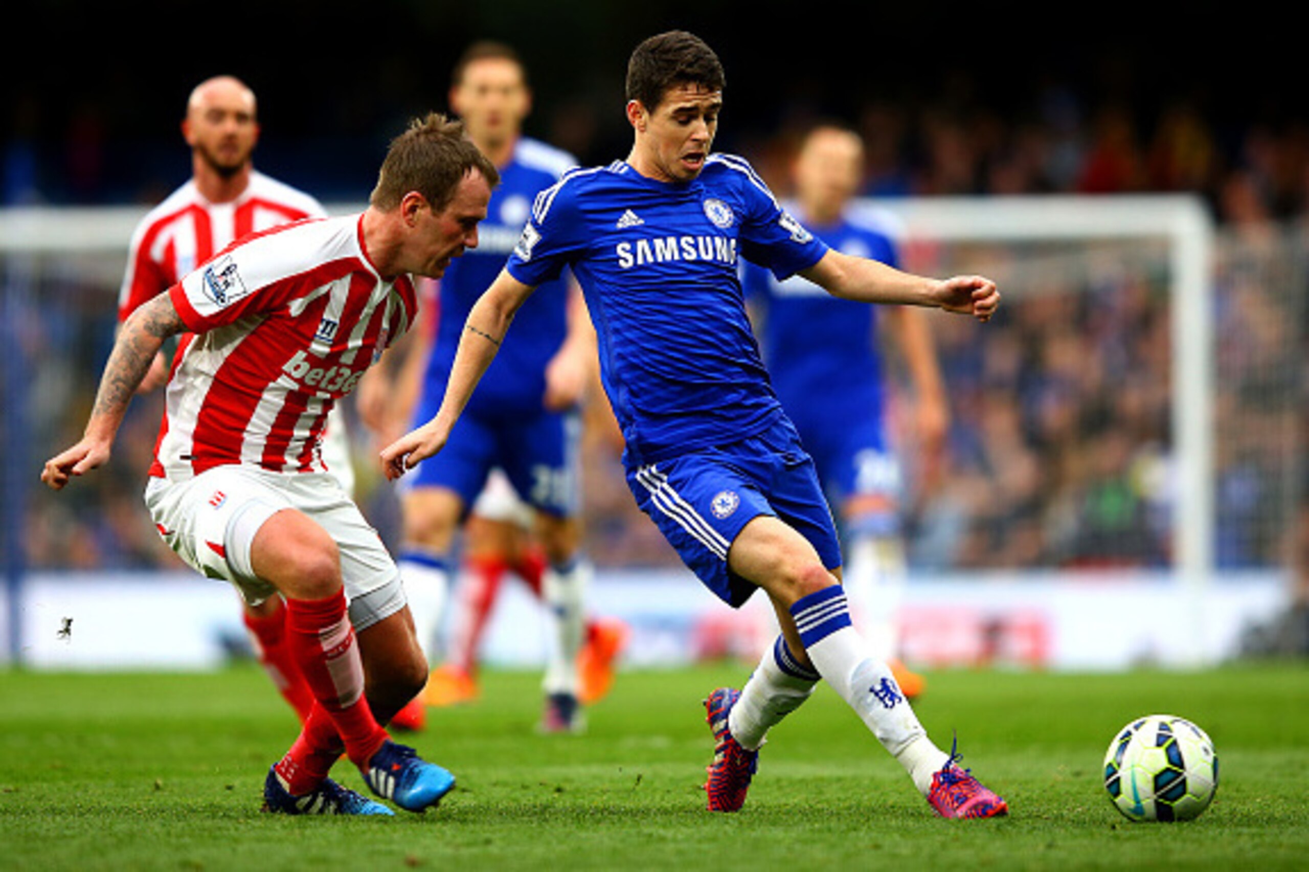 LONDON, ENGLAND - APRIL 04:  Oscar of Chelsea passes the ball under pressure from Glenn Whelan of Stoke City during the Barclays Premier League match between Chelsea and Stoke City at Stamford Bridge on April 4, 2015 in London, England.  (Photo by Richard