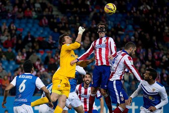 MADRID, SPAIN - FEBRUARY 21: Diego Godin of Atletico de Madrid wins the header after goalkeeper Julian Cuesta Diaz of Almeria UD during the La Liga match between Club Atletico de Madrid and UD Almeria at Vicente Calderon Stadium on February 21, 2015 in Ma
