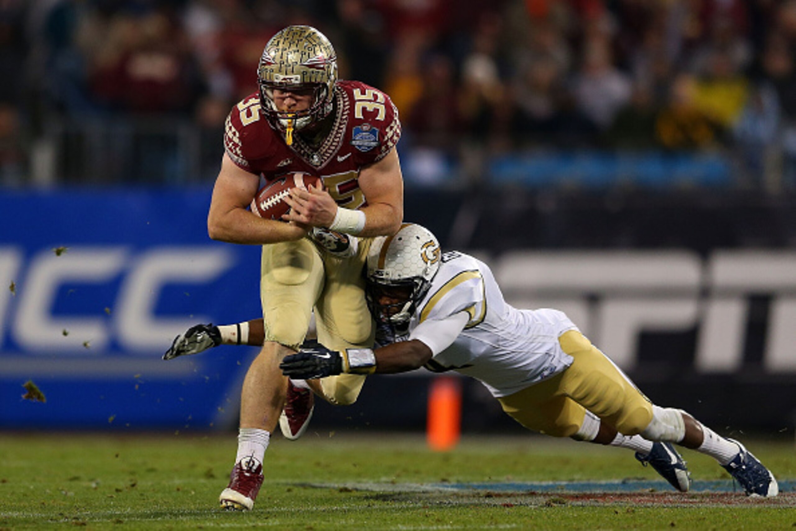 CHARLOTTE, NC - DECEMBER 06: Jamal Golden #4 of the Georgia Tech Yellow Jackets attempts a diving tackle against Nick O'Leary #35 of the Florida State Seminoles in the 2nd half during the ACC Championship game on December 6, 2014 in Charlotte, North Carol