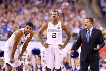 INDIANAPOLIS, IN - APRIL 04: Andrew Harrison #5, Aaron Harrison #2 and head coach John Calipari of the Kentucky Wildcats look on in the first half against the Wisconsin Badgers during the NCAA Men's Final Four Semifinal at Lucas Oil Stadium on April 4, 20
