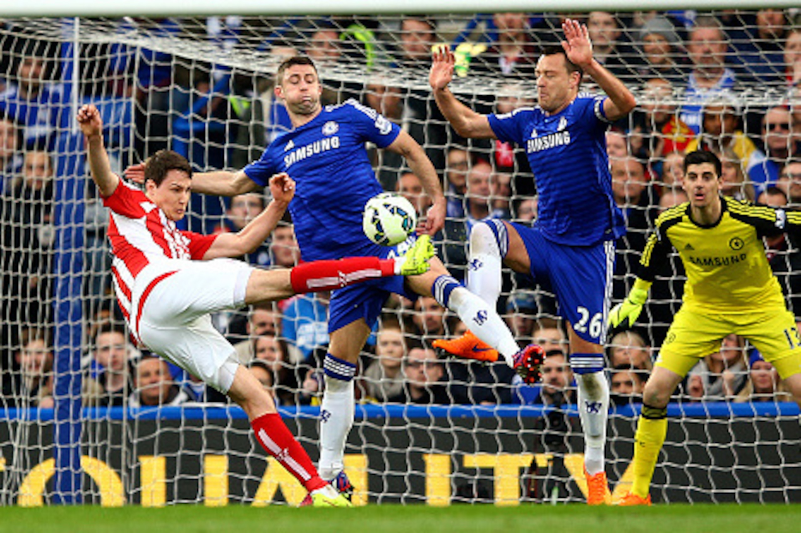 LONDON, ENGLAND - APRIL 04:  Philipp Wollscheid of Stoke City shoots at goal under pressure from John Terry of Chelsea and Gary Cahill of Chelsea during the Barclays Premier League match between Chelsea and Stoke City at Stamford Bridge on April 4, 2015 i