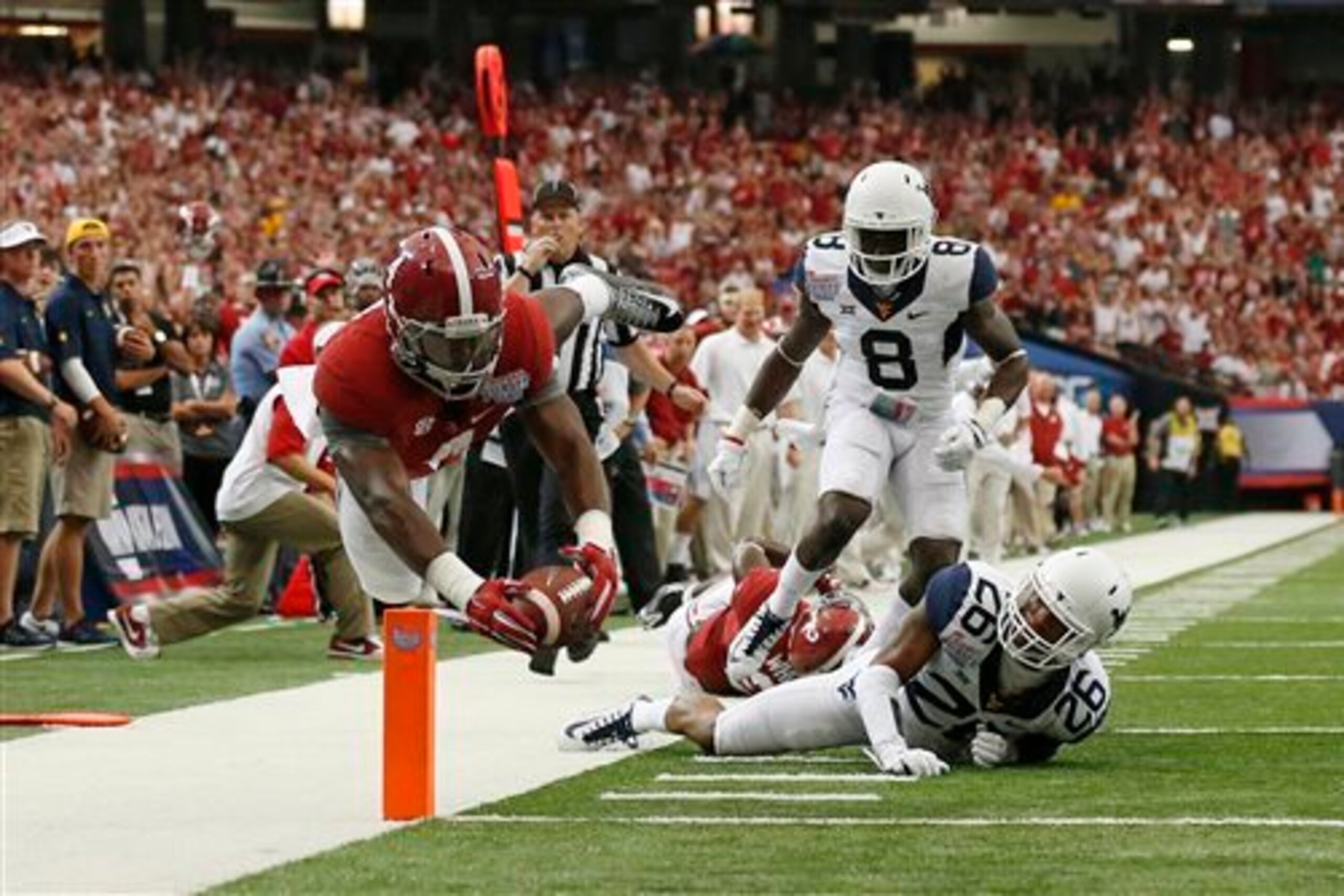 Alabama running back T.J. Yeldon (No. 4) leaps across the goal line for one of his two touchdowns in the season opener against West Virginia.