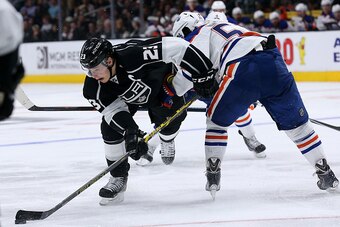 LOS ANGELES, CA - APRIL 02:   Dustin Brown #23 of the Los Angeles Kings works against Anton Lander #51 of the Edmonton Oilers at Staples Center on April 2, 2015 in Los Angeles, California.  The Kings won 8-2.  (Photo by Stephen Dunn/Getty Images)