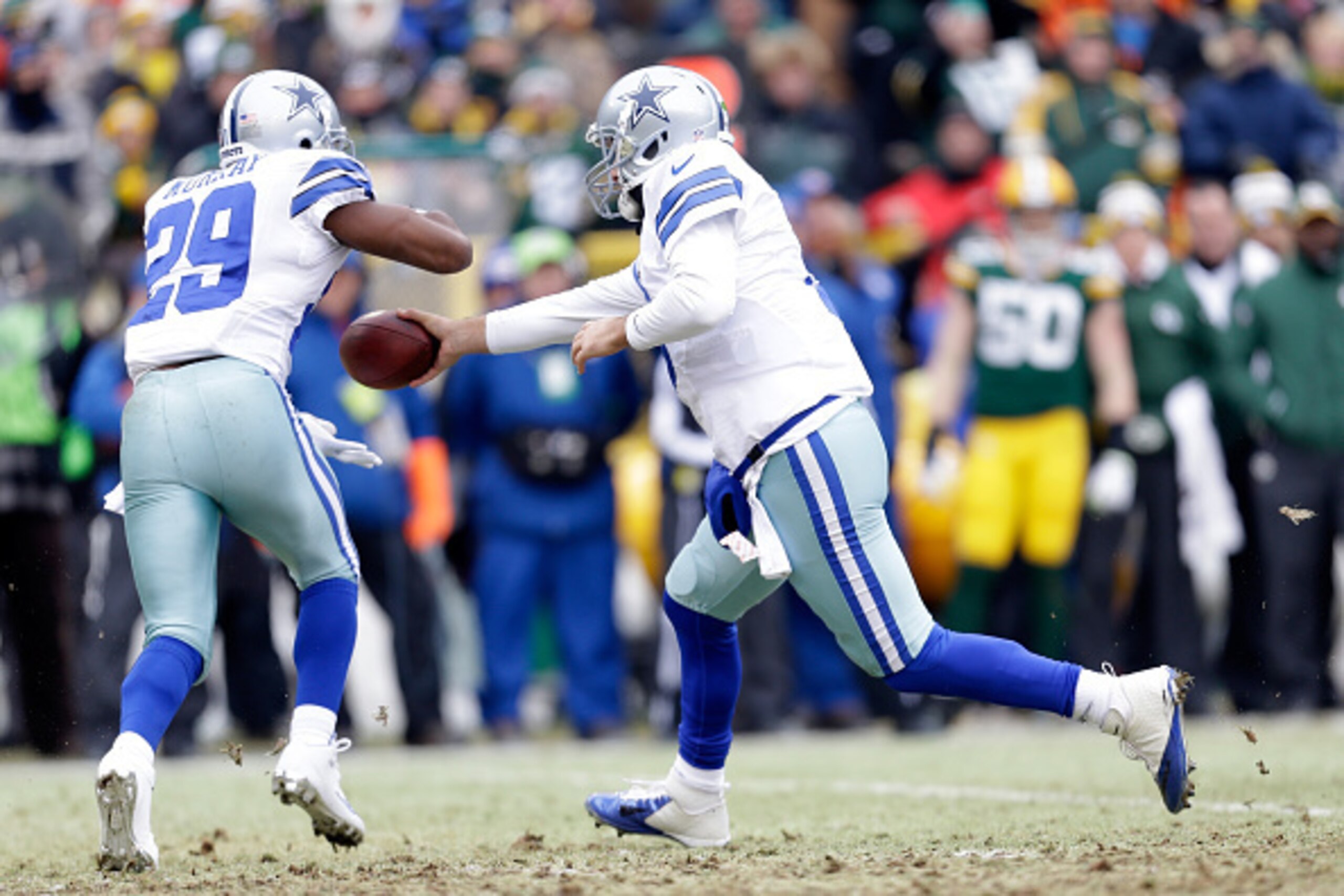 GREEN BAY, WI - JANUARY  Tony Romo #9 of the Dallas Cowboys hands the football off to  DeMarco Murray #29 in the first quarter of the 2015 NFC Divisional Playoff game against the Green Bay Packers at Lambeau Field on January 11, 2015 in Green Bay, Wiscons