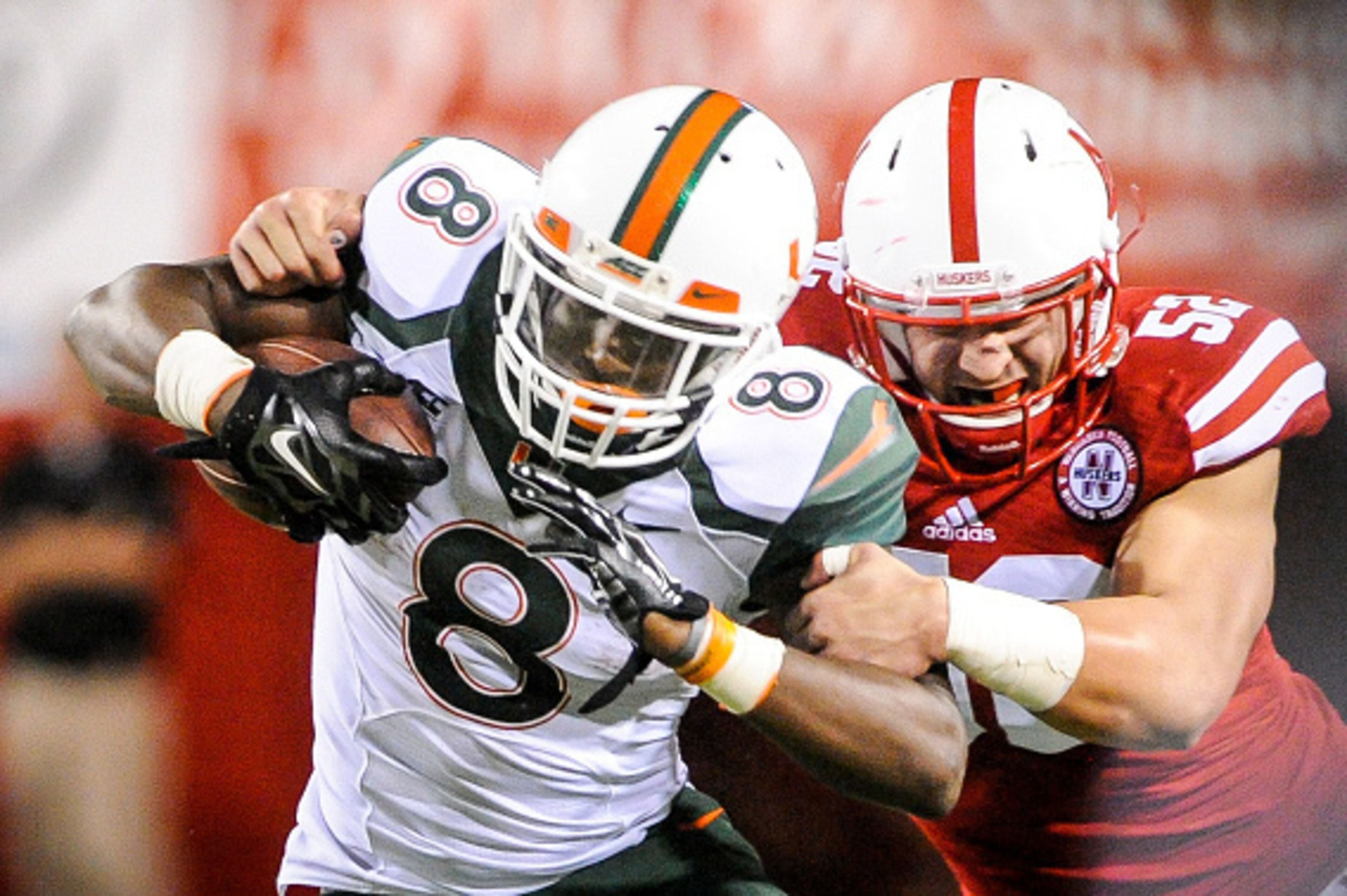 LINCOLN, NE - SEPTEMPER 20: Linebacker Josh Banderas #52 of the Nebraska Cornhuskers wraps up running back Duke Johnson #8 of the Miami Hurricanes during their game at Memorial Stadium on September 20, 2014 in Lincoln, Nebraska. Nebraska defeated Miami 41