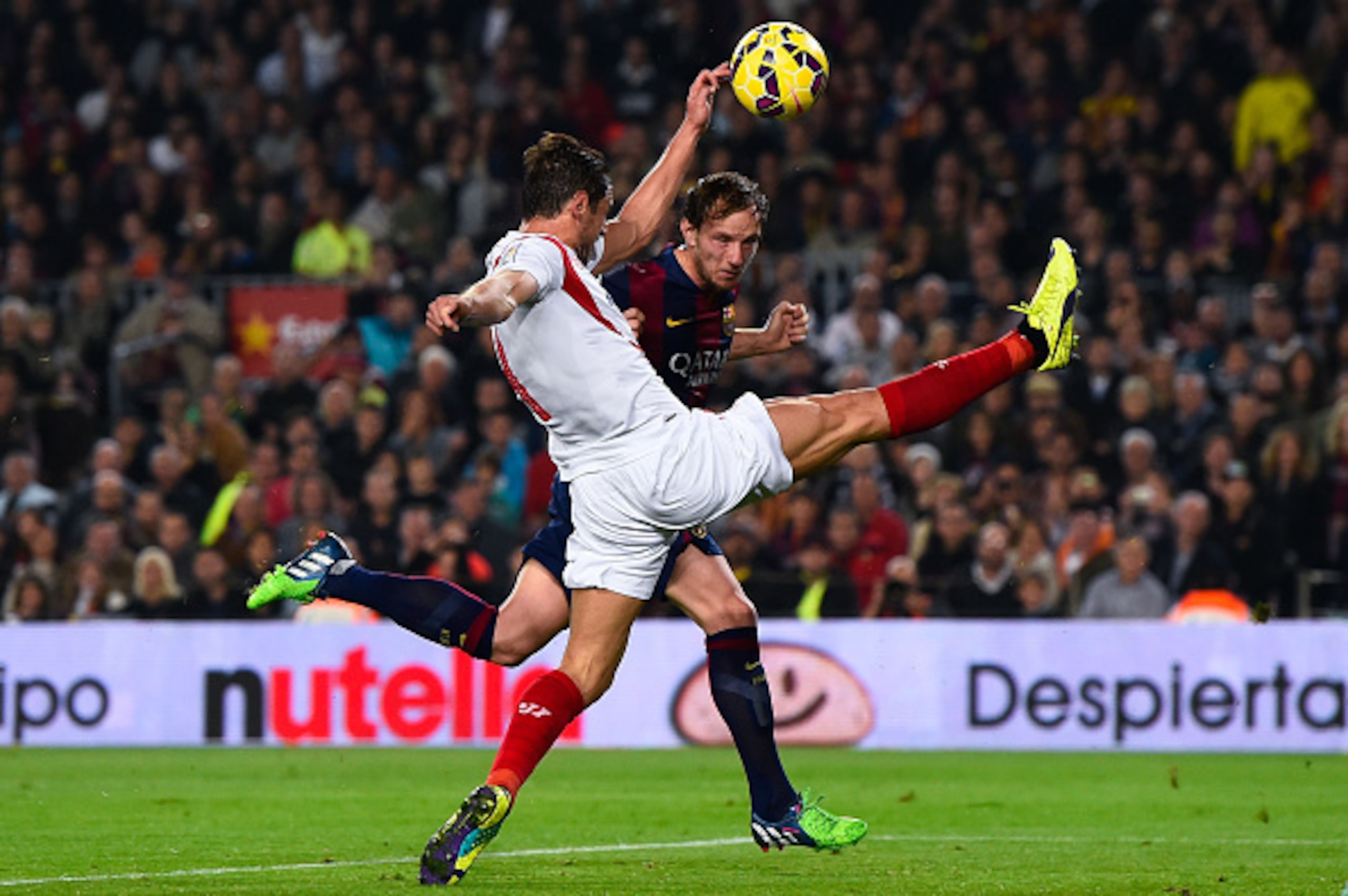 BARCELONA, SPAIN - NOVEMBER 22:  Ivan Rakitic of FC Barcelona scores his team's third goal under a challenge by Grzegorz Krychowiak of Sevilla FC during the La Liga match between FC Barcelona and Sevilla FC at Camp Nou on November 22, 2014 in Barcelona, S