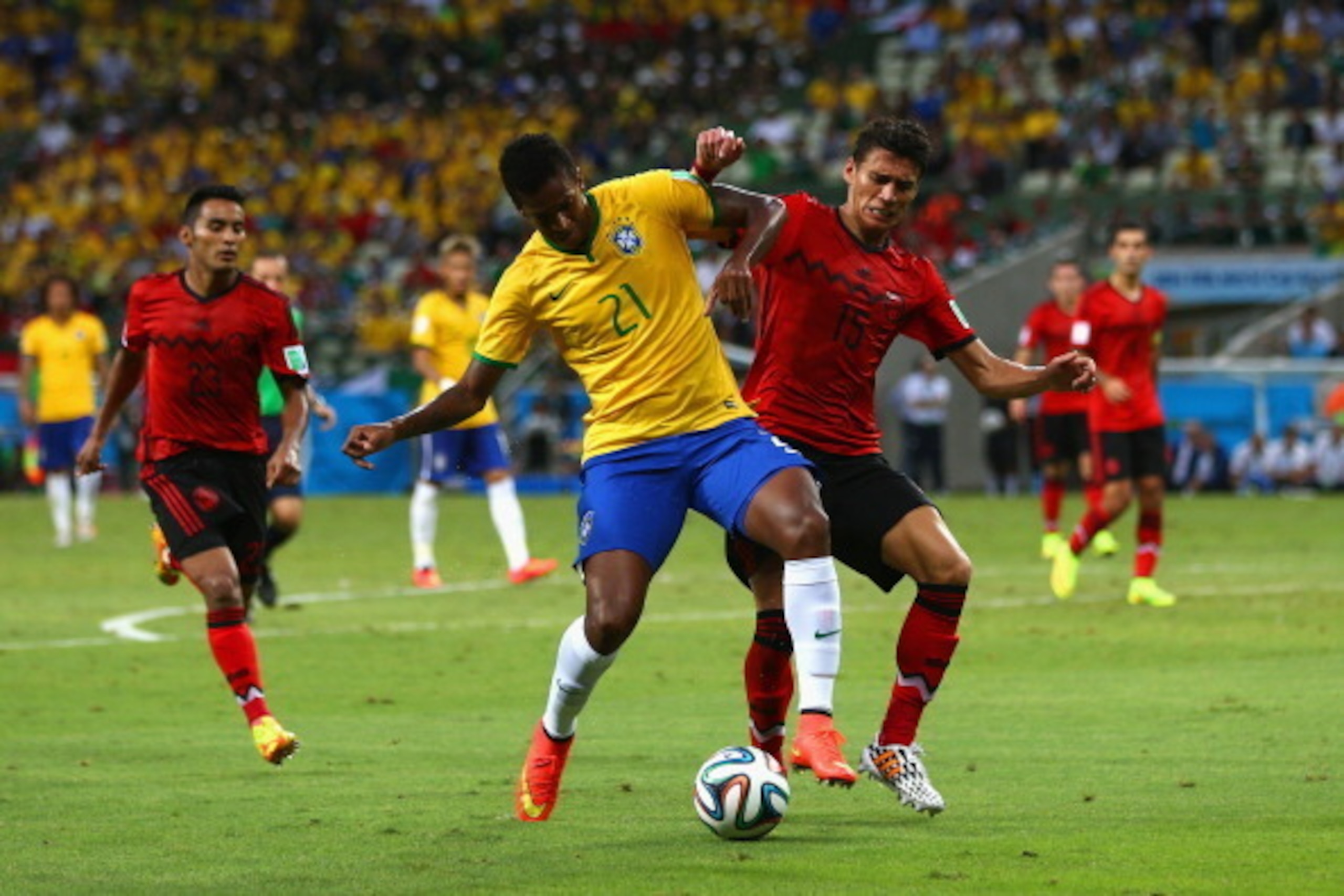 FORTALEZA, BRAZIL - JUNE 17: Jo of Brazil is challenged by Hector Moreno of Mexico during the 2014 FIFA World Cup Brazil Group A match between Brazil and Mexico at Castelao on June 17, 2014 in Fortaleza, Brazil.  (Photo by Michael Steele/Getty Images)