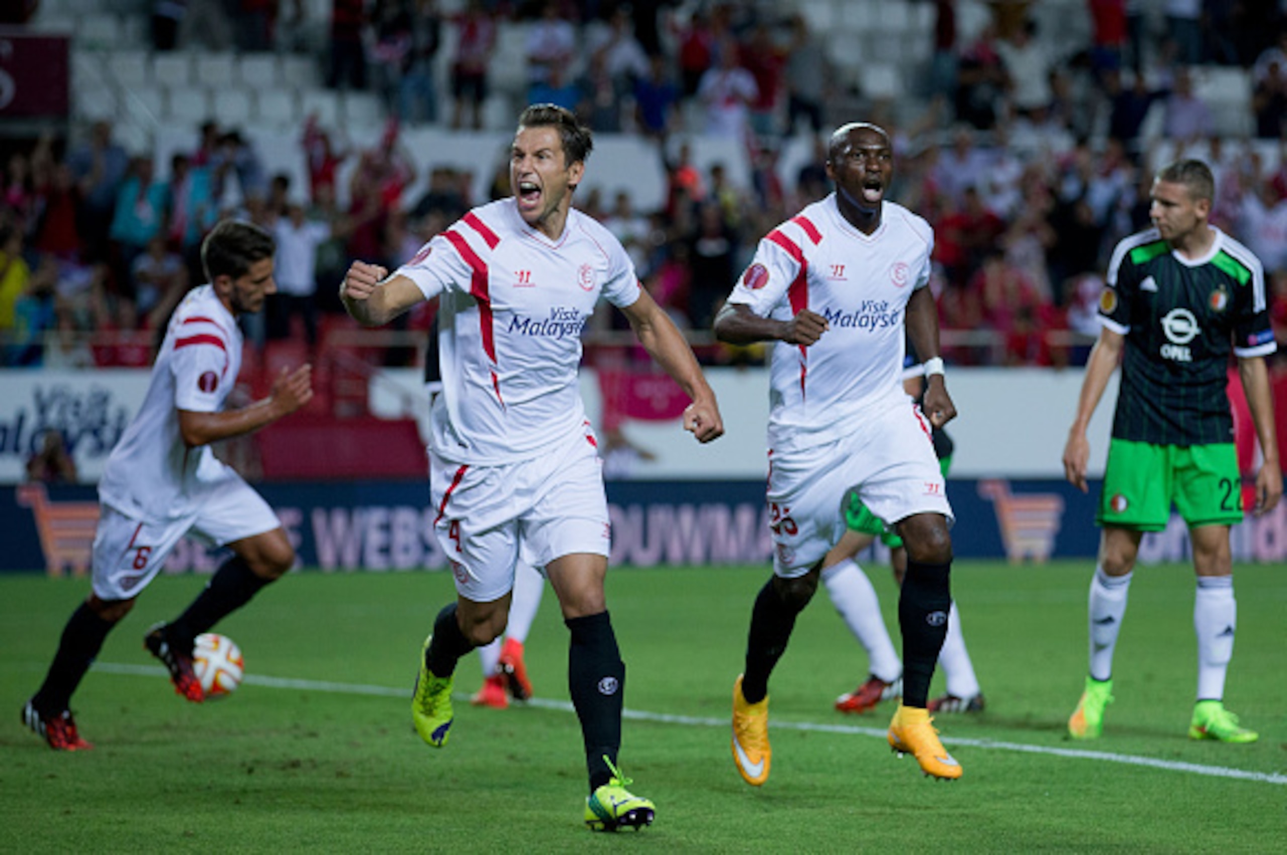 SEVILLE, SPAIN - SEPTEMBER 18:  Grzegorz Krychowiak (L) of Sevilla FC celebrates scoring their opening goal with teammate Stephane Mbia Etoundi (R) during the UEFA Europa League group G match between Sevilla FC and Feyenoord at Ramon Sanchez Pizjuan stadi