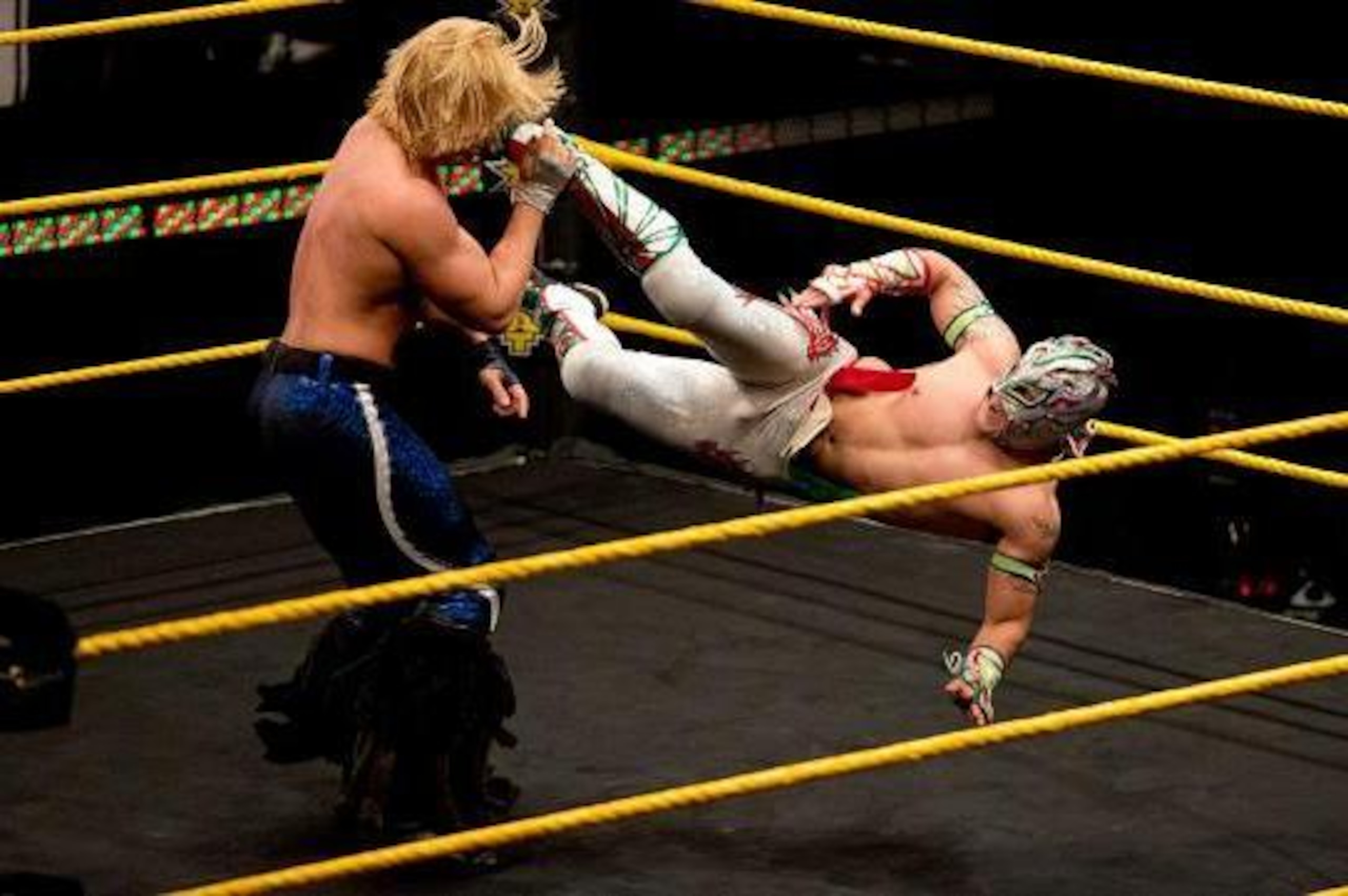 Kalisto dropkicks Tyler Breeze.