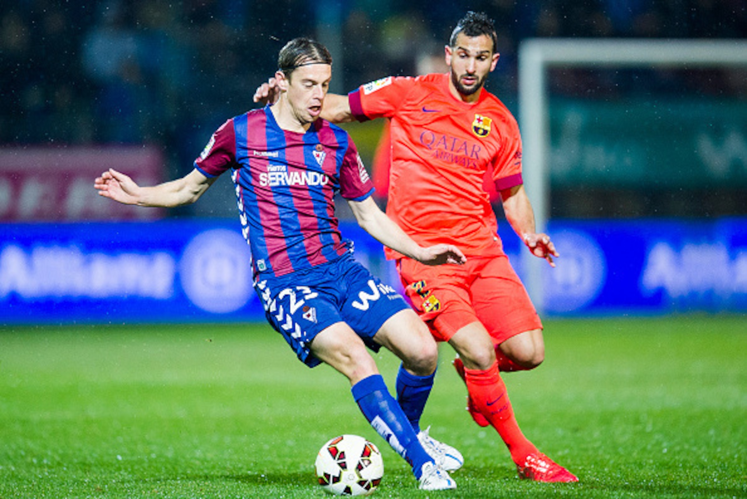 EIBAR, SPAIN - MARCH 14:  Martin Montoya of FC Barcelona duels for the ball with Javier Lara of SD Eibar during the La Liga match between SD Eibar and FC Barcelona at Ipurua Municipal Stadium on March 14, 2015 in Eibar, Spain.  (Photo by Juan Manuel Serra