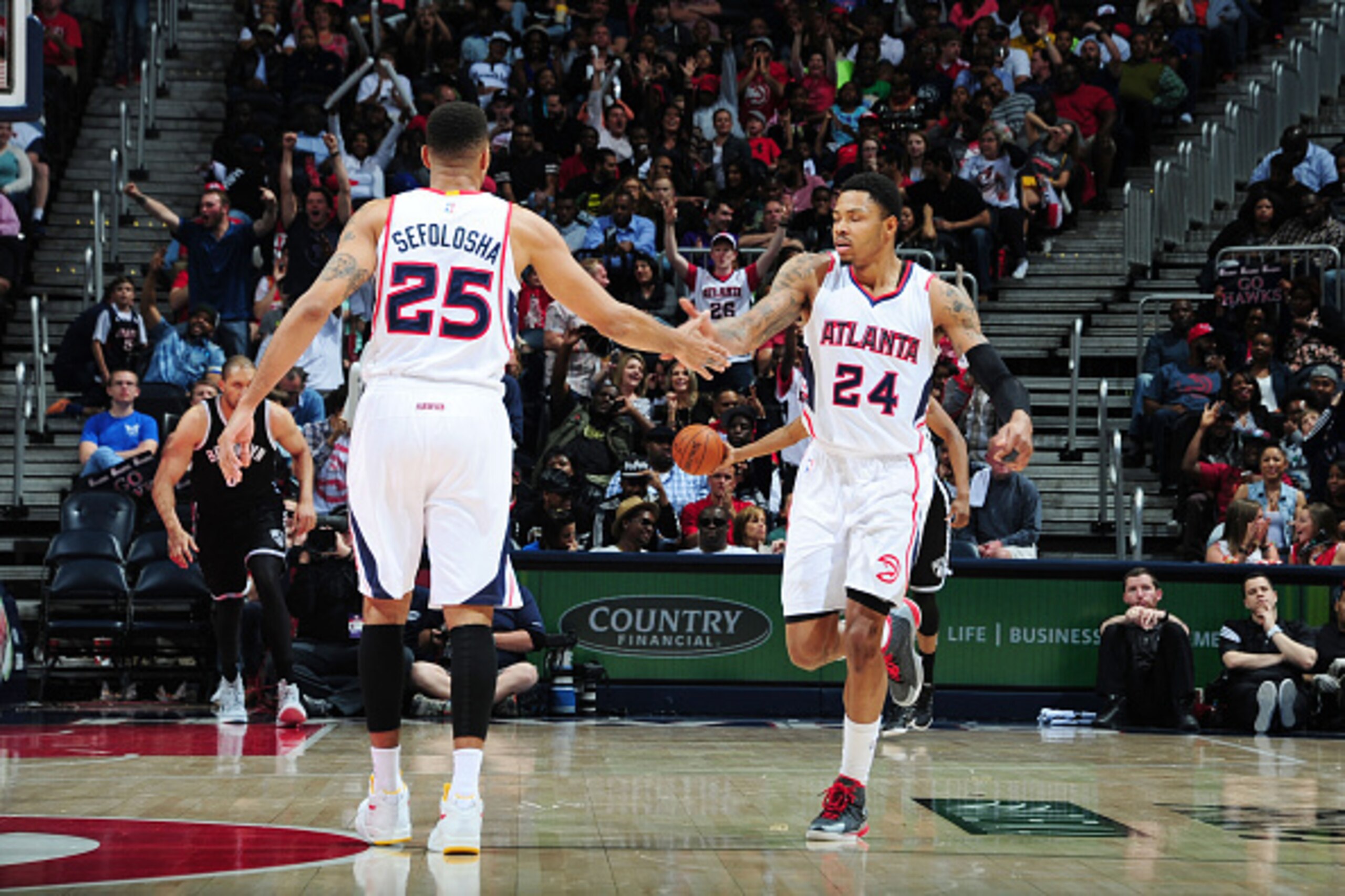 ATLANTA, GA - APRIL 4: Thabo Sefolosha #25 high fives teammate Kent Bazemore #24 of the Atlanta Hawks during the game against the Brooklyn Nets on April 4, 2015 at Philips Arena in Atlanta, Georgia. NOTE TO USER: User expressly acknowledges and agrees tha