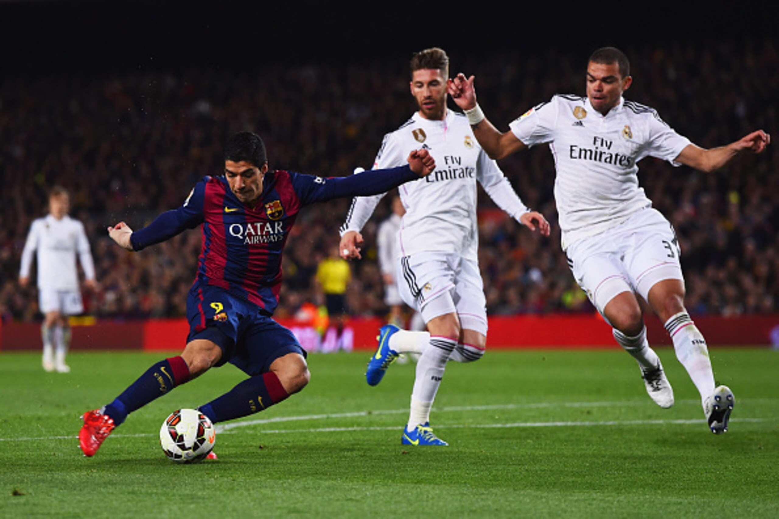 BARCELONA, SPAIN - MARCH 22:  Luis Suarez of Barcelona shoots past Sergio Ramos and Pepe of Real Madrid CF to score their second goal during the La Liga match between FC Barcelona and Real Madrid CF at Camp Nou on March 22, 2015 in Barcelona, Spain.  (Pho