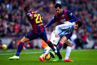 BARCELONA, SPAIN - FEBRUARY 21:  Juanmi Jimenez of Malaga CF competes for the ball with Sergio Busquets and Dani Alves of FC Barcelona during the La Liga match between FC Barcelona and Malaga CF at Camp Nou on February 21, 2015 in Barcelona, Spain.  (Phot