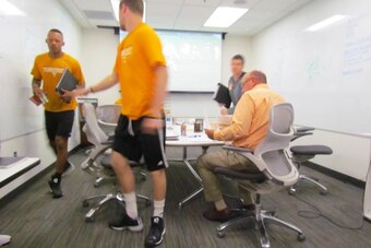 Tennessee's quarterbacks break from the meeting room as new offensive coordinator Mike DeBord (right) wraps up.