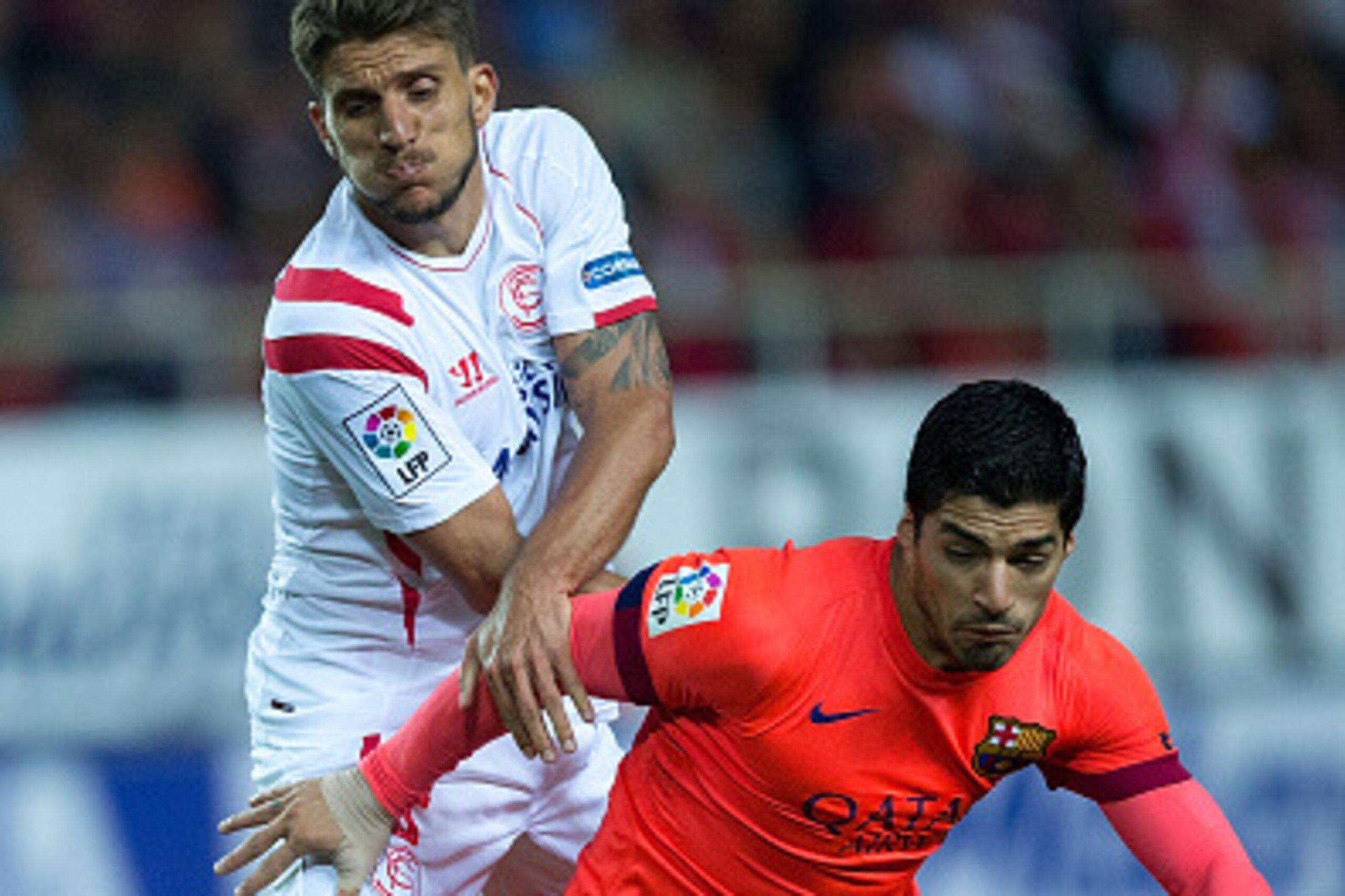 SEVILLE, SPAIN - APRIL 11: Luis Suarez (R) of FC Barcelona competes for the ball with Daniel Carrico (L) of Sevilla FC during the La Liga match between Sevilla FC and FC Barcelona at Estadio Ramon Sanchez Pizjuan on April 11, 2015 in Seville, Spain.  (Pho