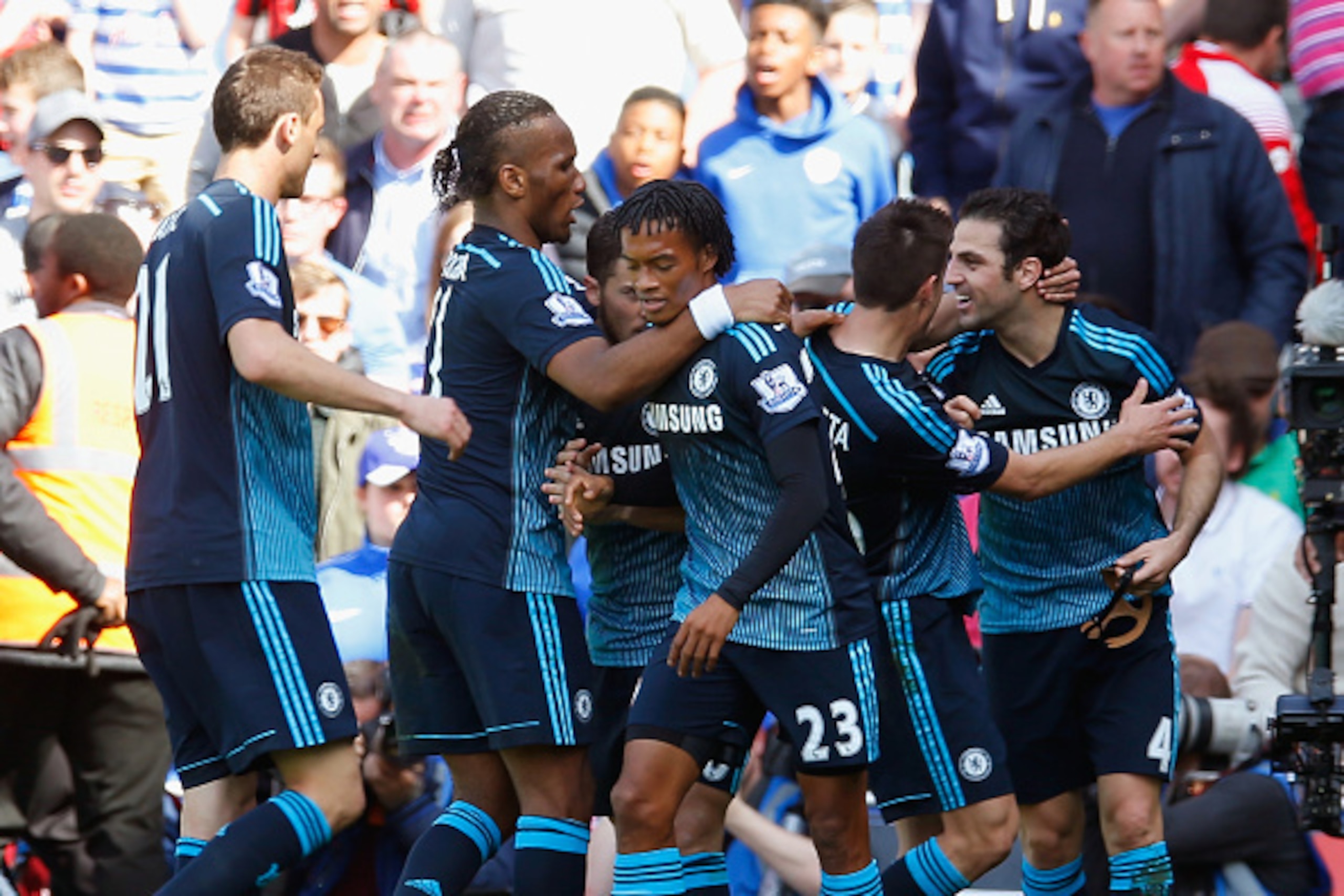 LONDON, ENGLAND - APRIL 12:  Cesc Fabregas of Chelsea celebrates scoring the opening goal with team mates during the Barclays Premier League match between Queens Park Rangers and Chelsea at Loftus Road on April 12, 2015 in London, England.  (Photo by Stev