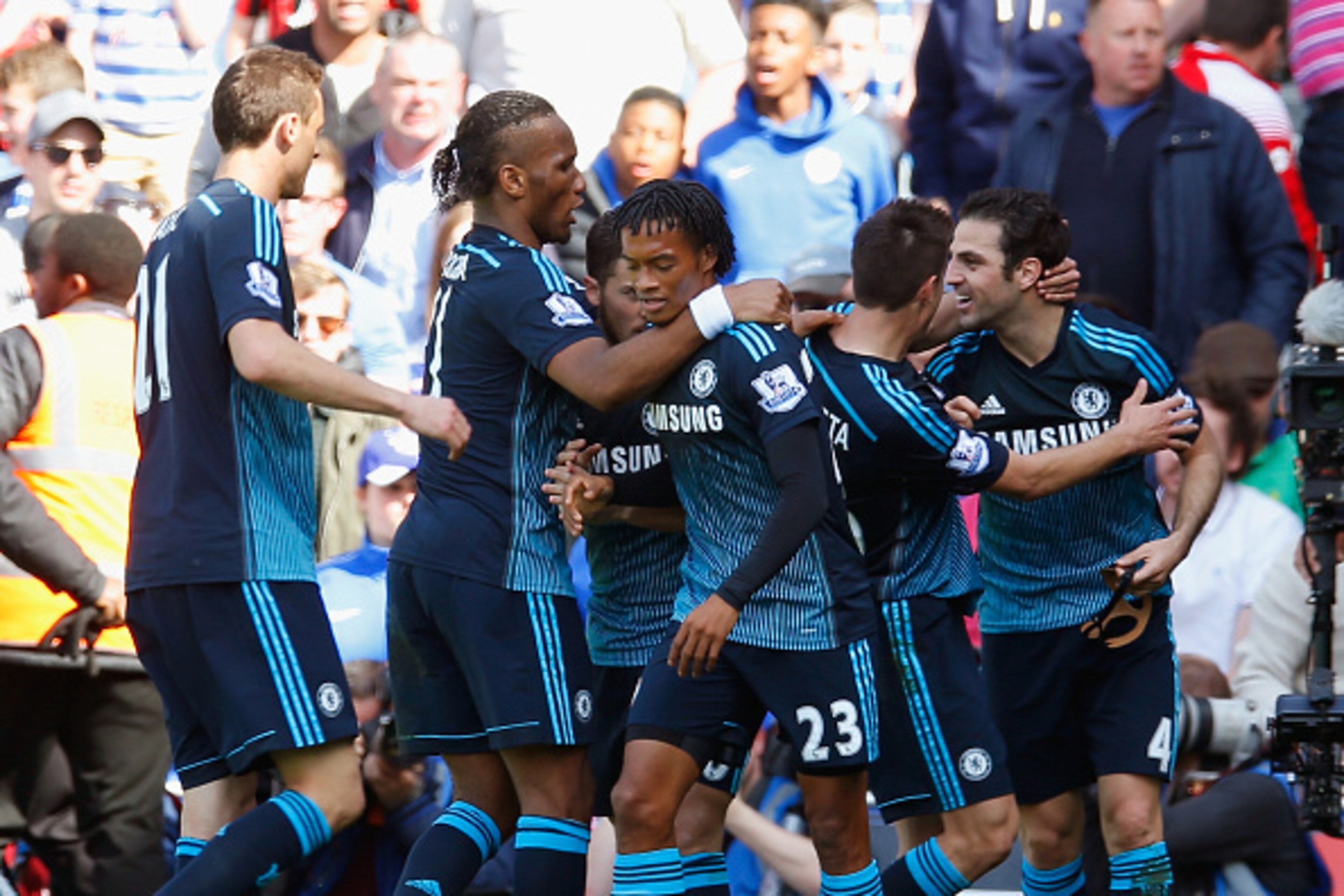 LONDON, ENGLAND - APRIL 12:  Cesc Fabregas of Chelsea celebrates scoring the opening goal with team mates during the Barclays Premier League match between Queens Park Rangers and Chelsea at Loftus Road on April 12, 2015 in London, England.  (Photo by Stev