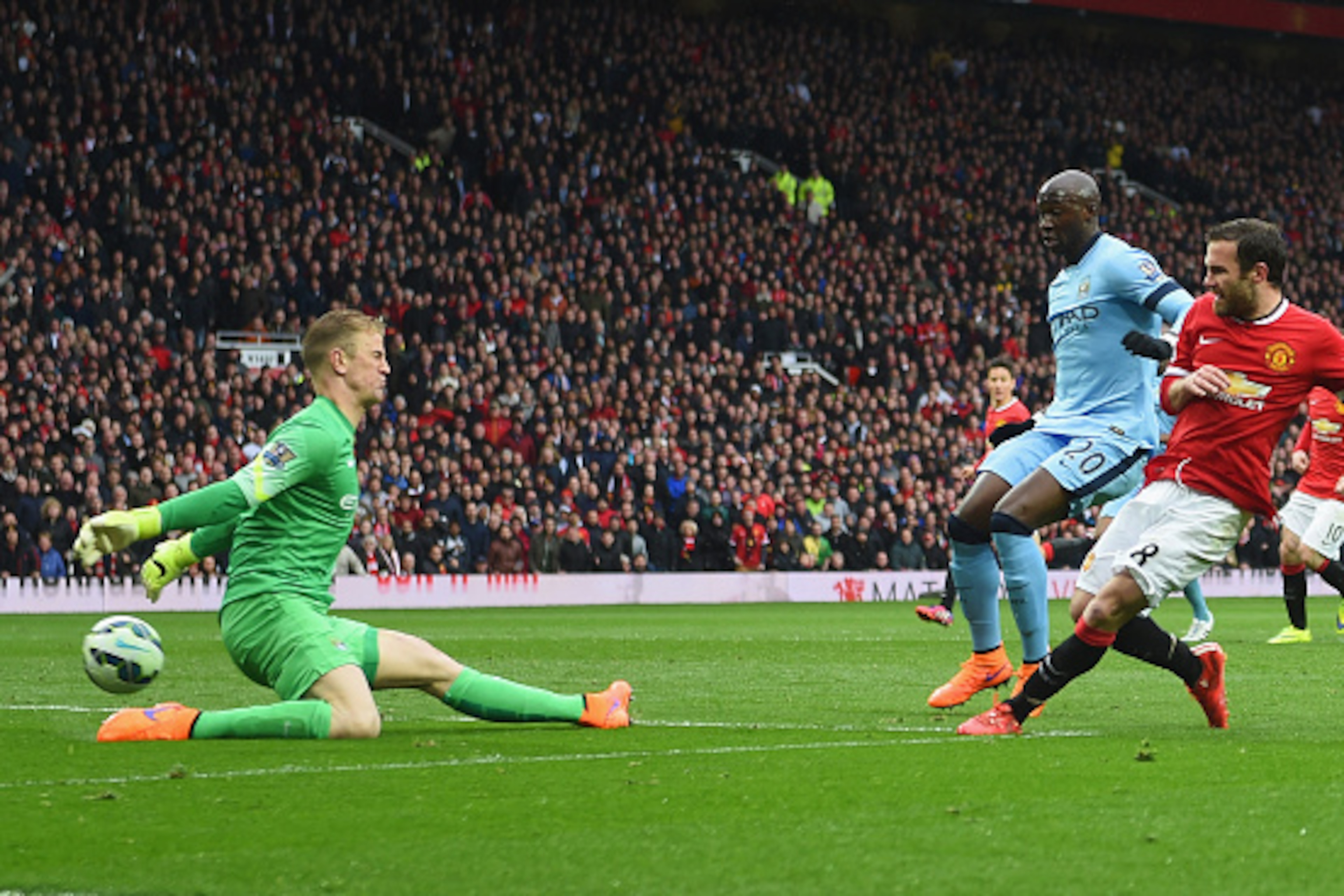MANCHESTER, ENGLAND - APRIL 12:  Juan Mata of Manchester United shoots past Joe Hart of Manchester City to score their third goal during the Barclays Premier League match between Manchester United and Manchester City at Old Trafford on April 12, 2015 in M